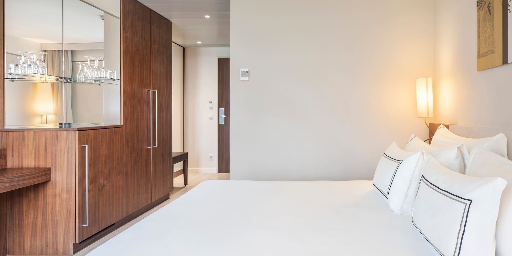 a bed with white sheets and a lamp