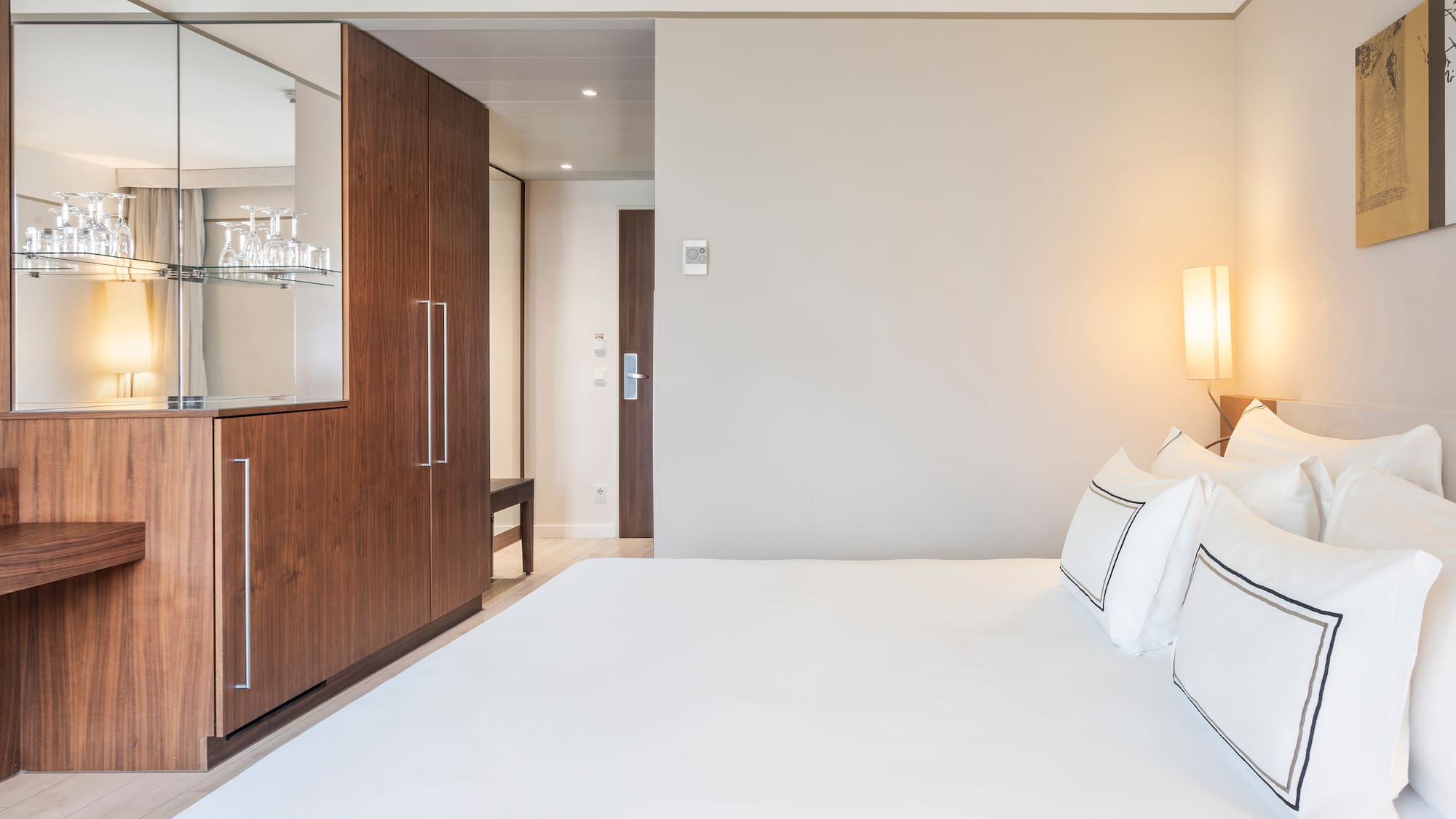 a bed with white sheets and a lamp