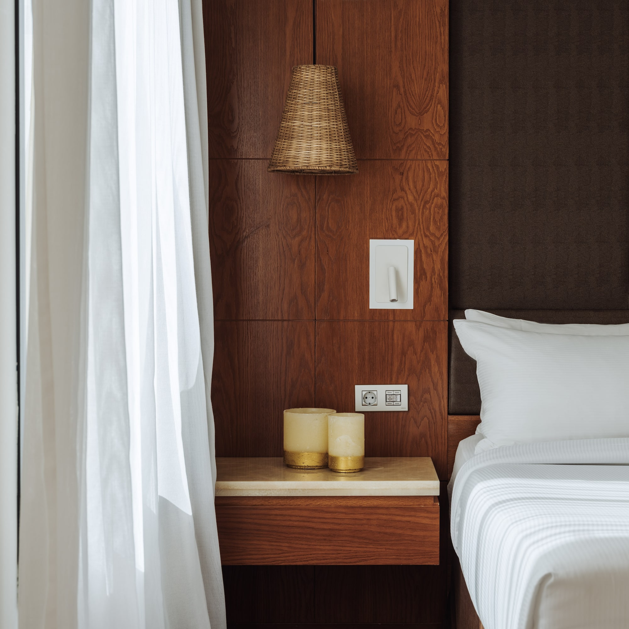 a bed with white sheets and a lamp on a table
