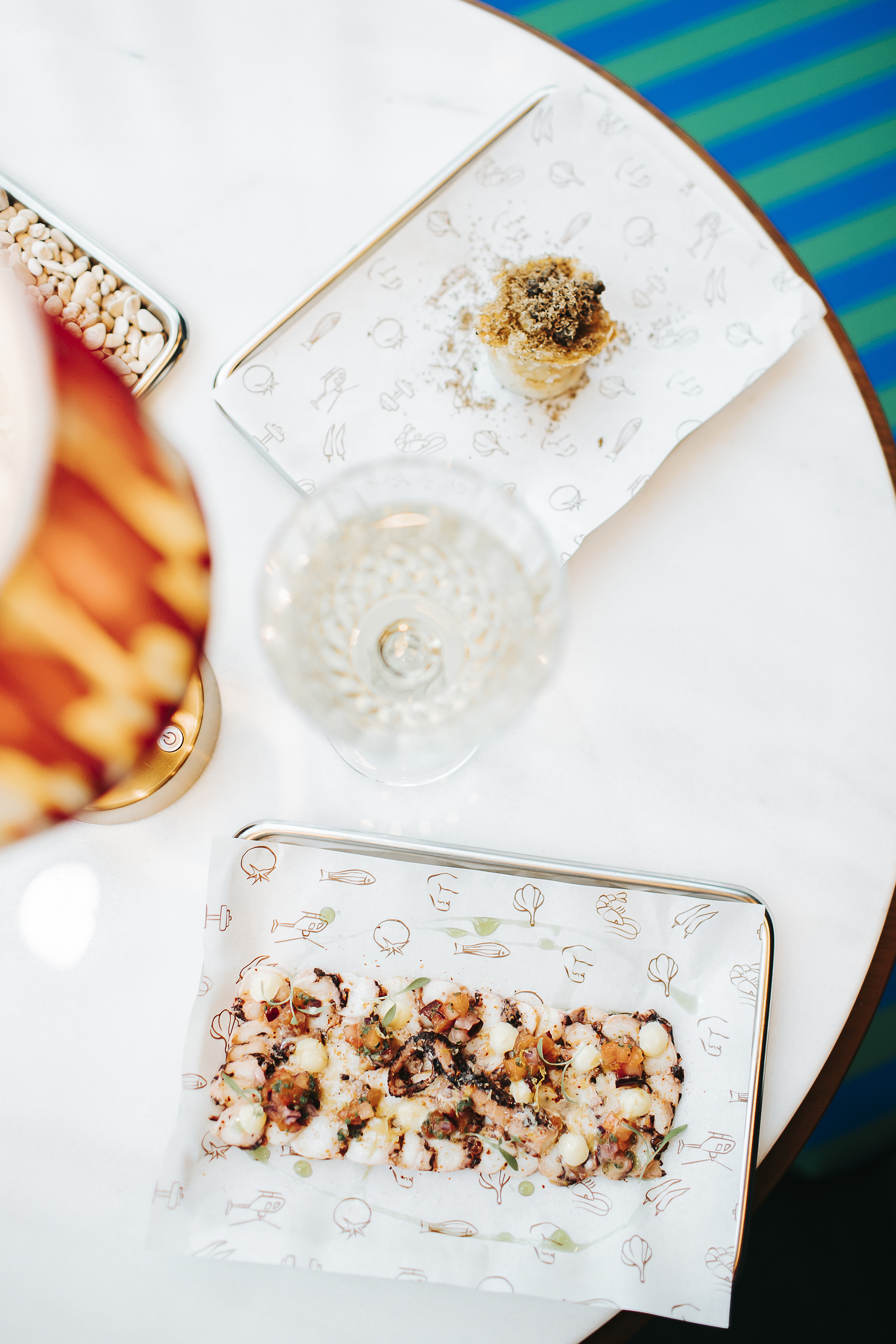 Gourmet seafood carpaccio, truffle appetizer, and wine on a dining table.