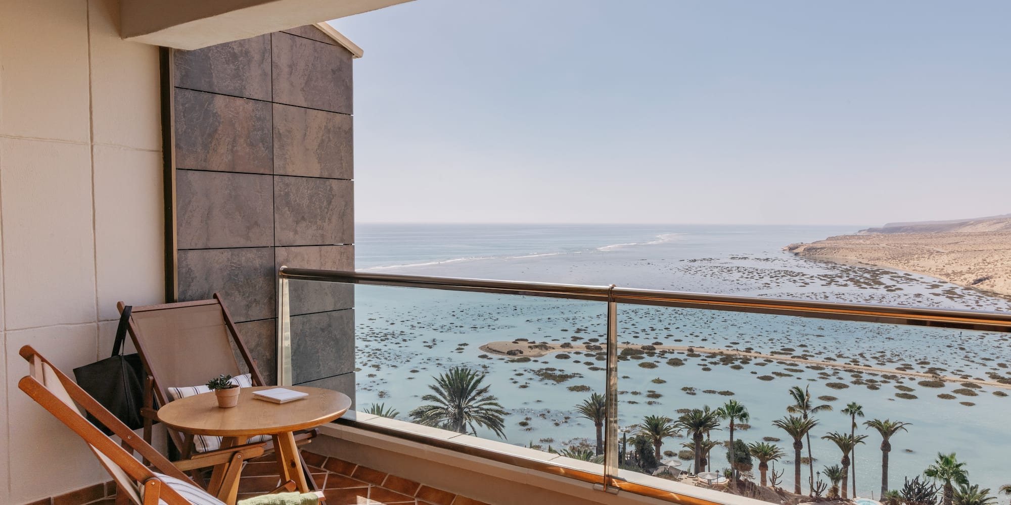 a balcony with a table and chairs overlooking the ocean