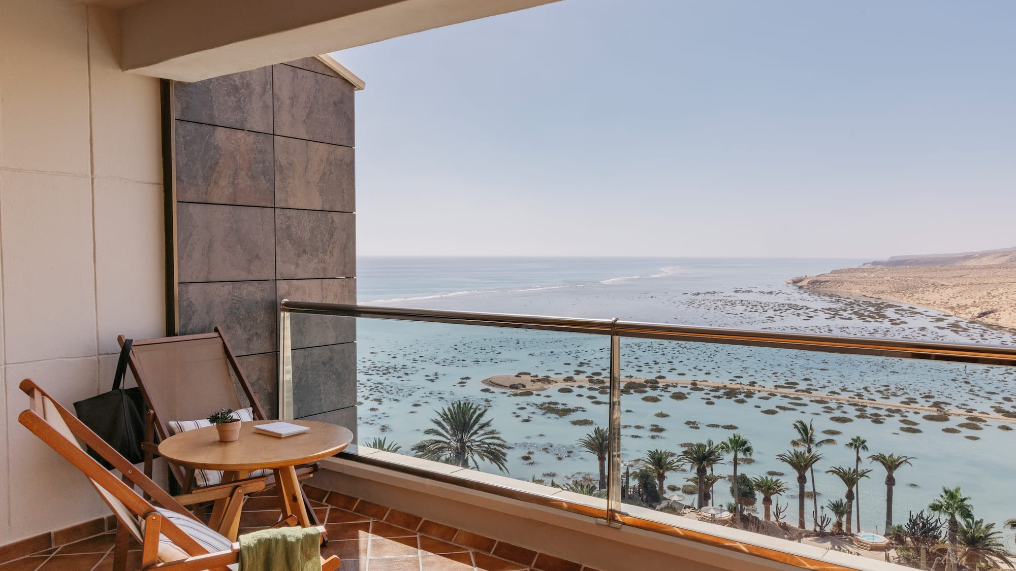 a balcony with a table and chairs overlooking the ocean