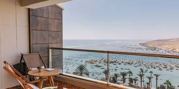 a balcony with a table and chairs overlooking the ocean