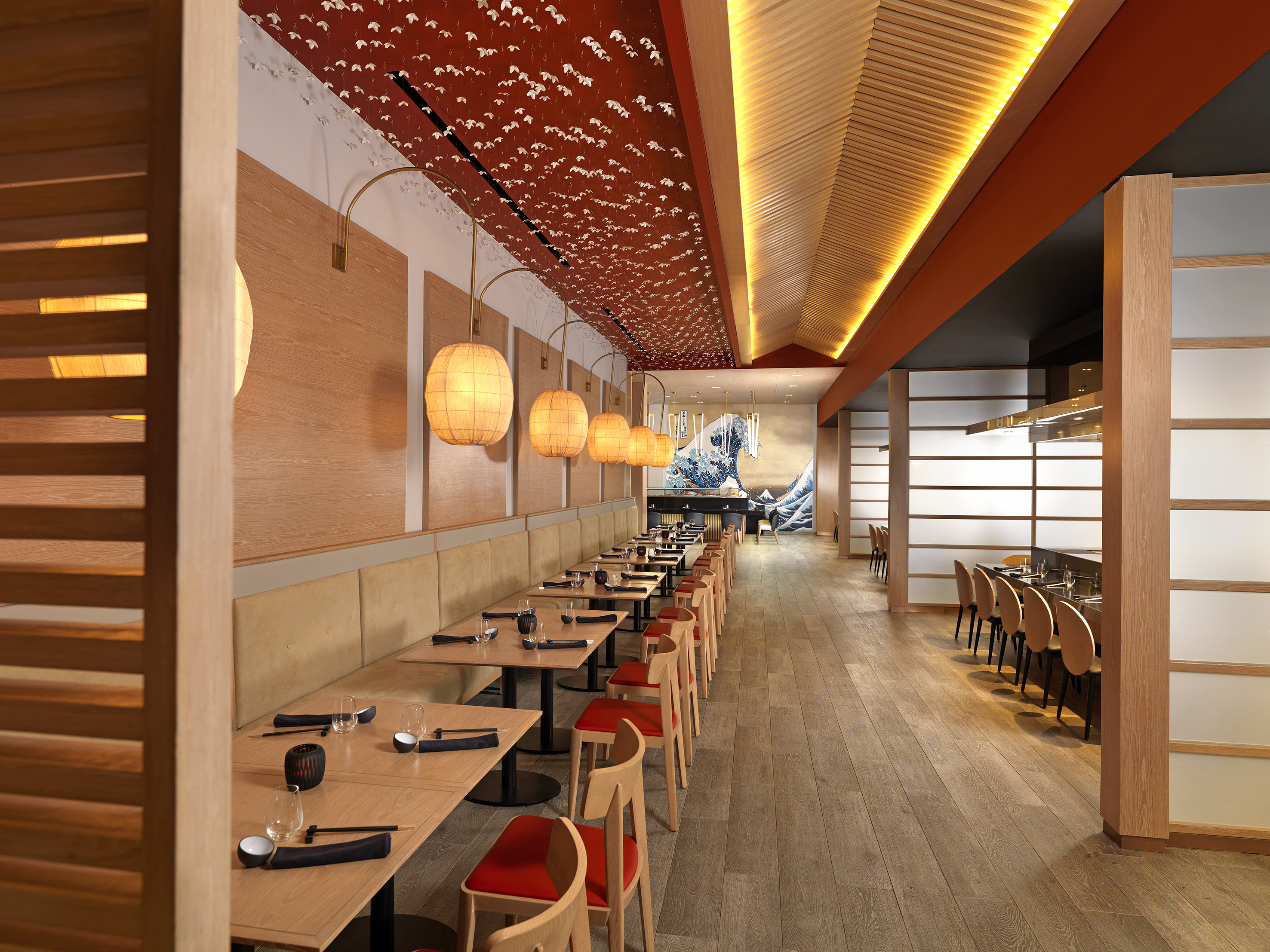 Japanese restaurant dining room with red ceiling, lanterns, and Great Wave art.