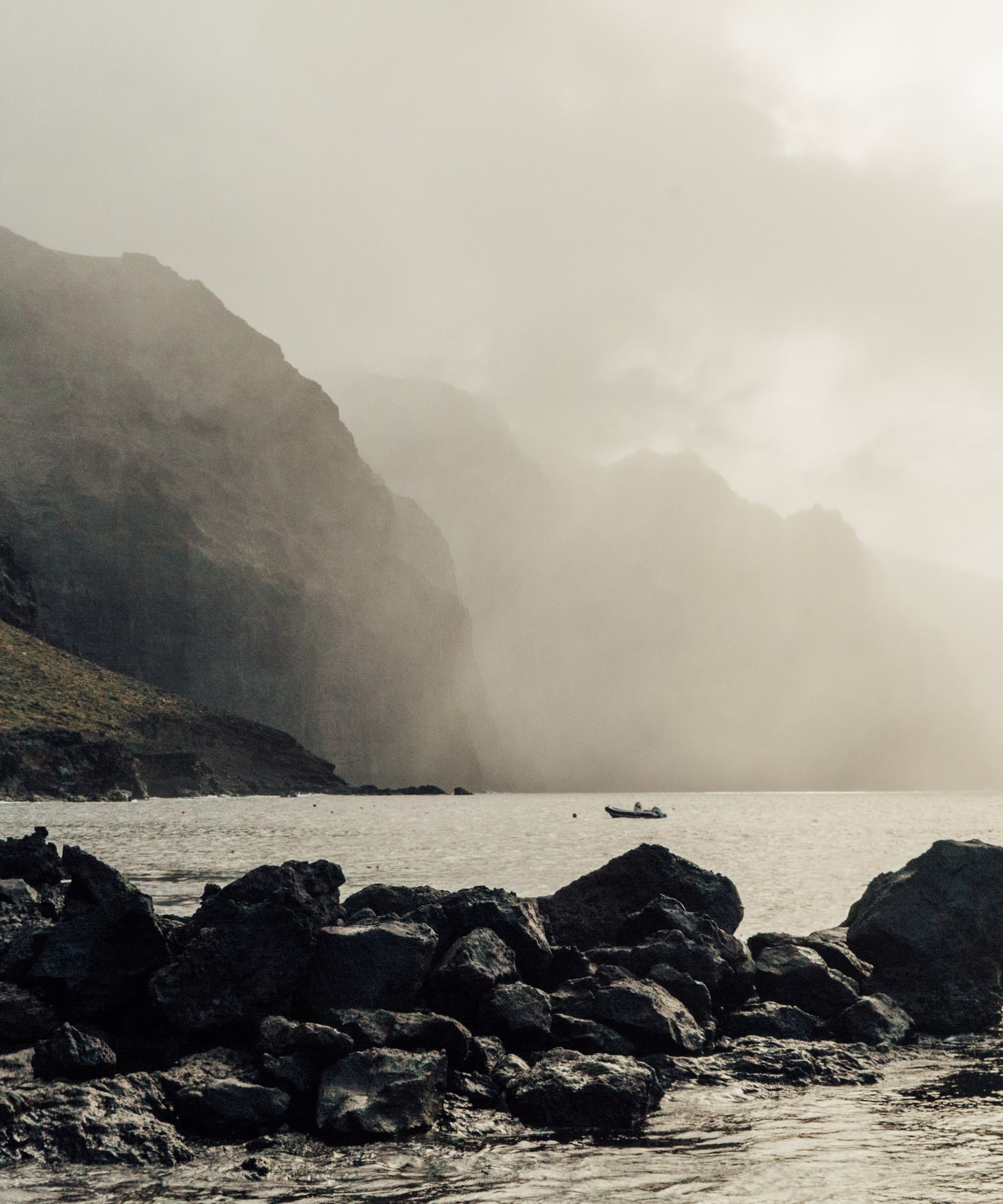 a rocky shore with a boat in the water