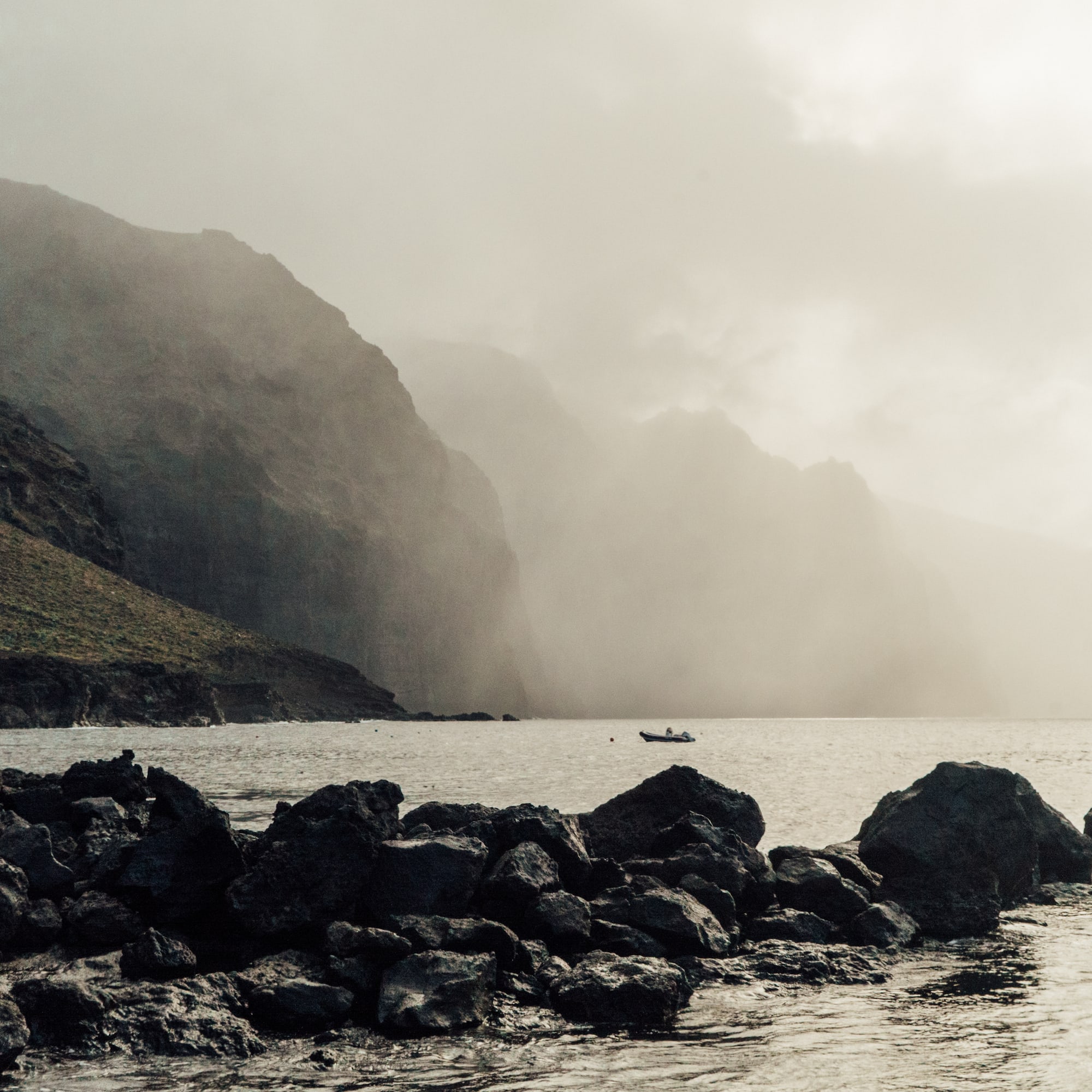 a rocky shore with a boat in the water