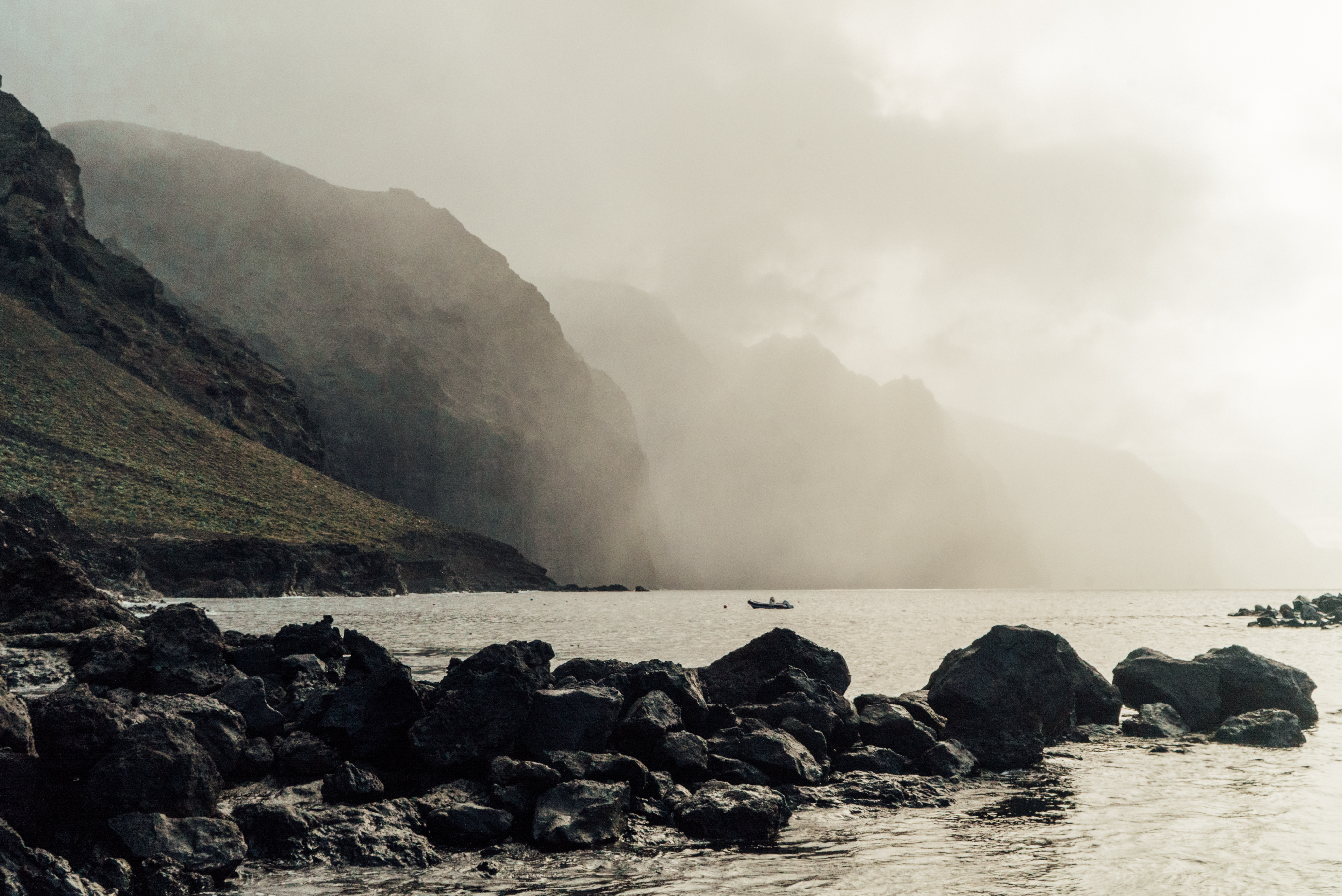 a rocky shore with a boat in the water