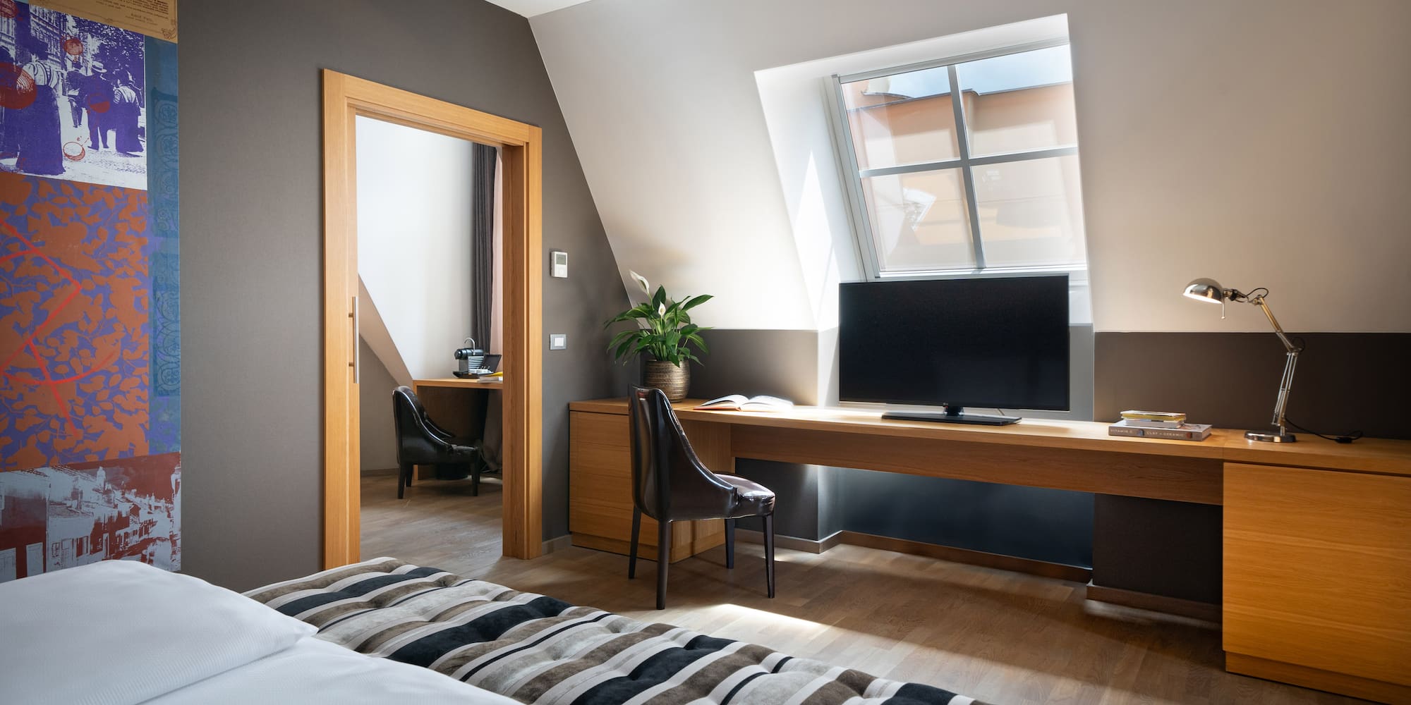 a room with a bed and a desk and a tv