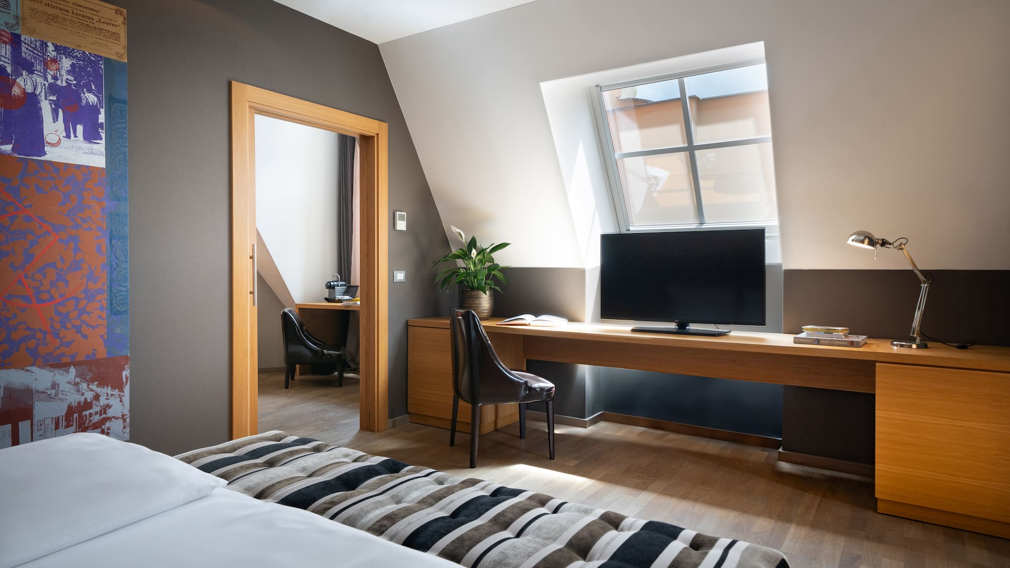 a room with a bed and a desk and a tv