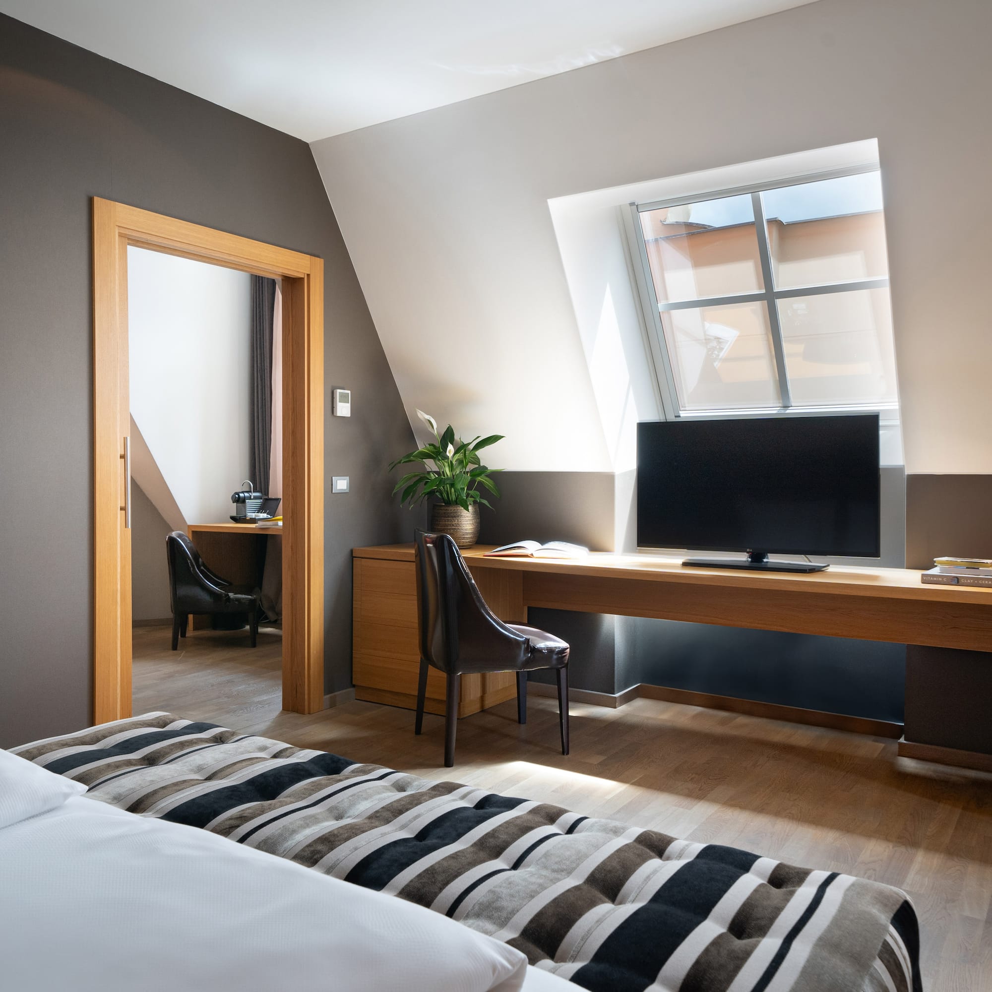 a room with a bed and a desk and a tv