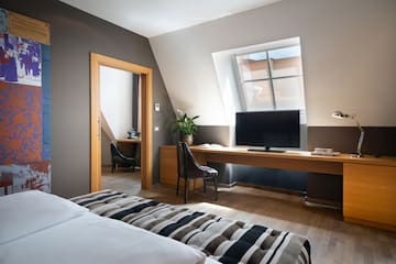 a room with a bed and a desk and a tv
