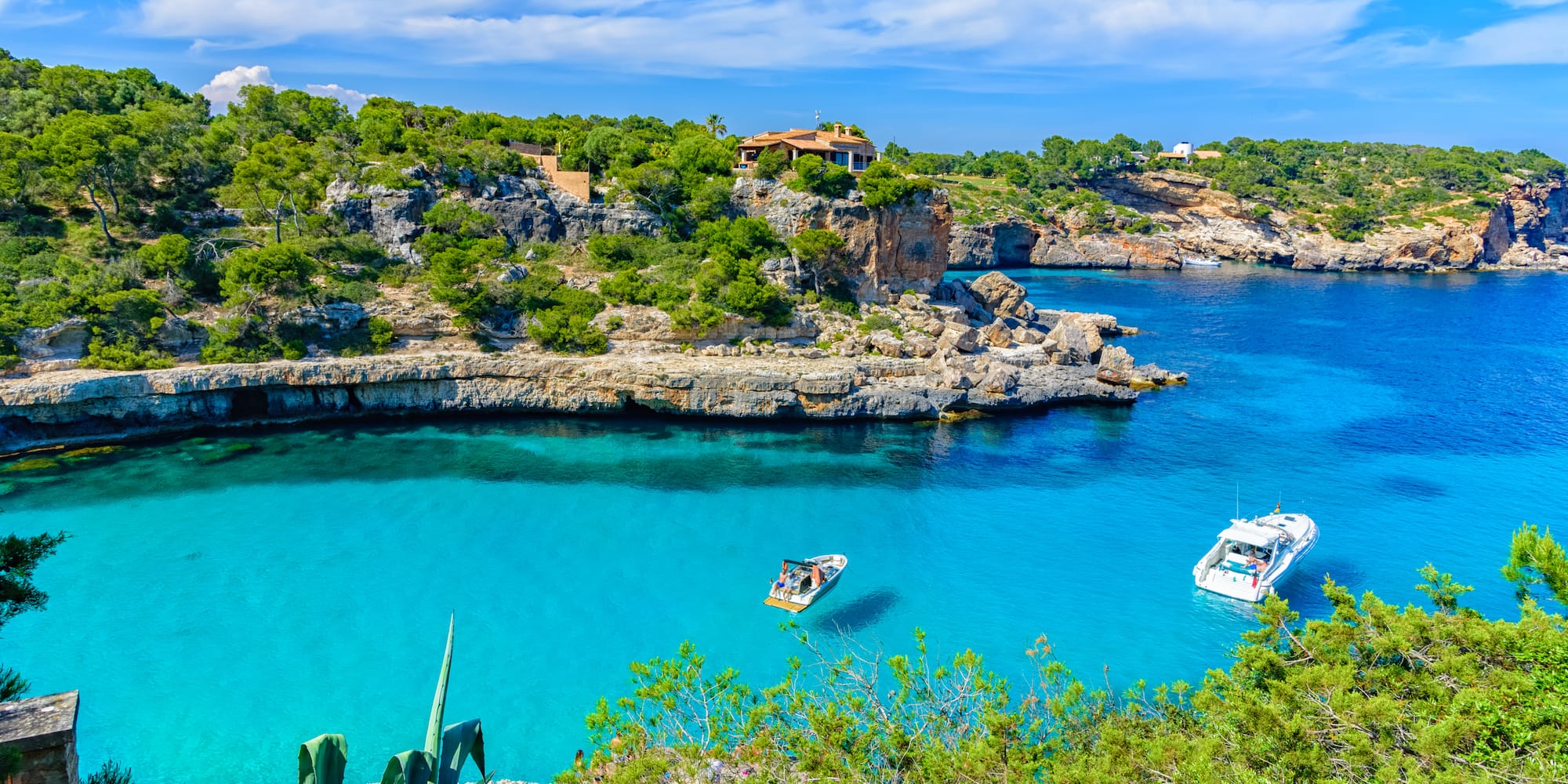 boats in a body of water with a house on the side