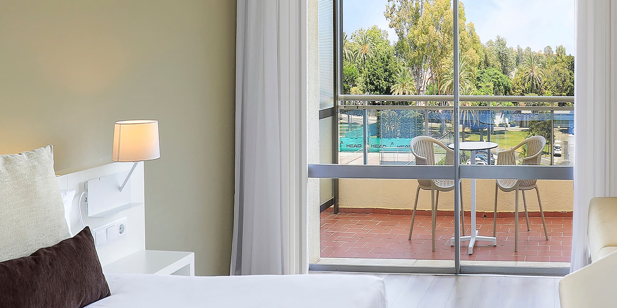 a bedroom with two beds and a glass door