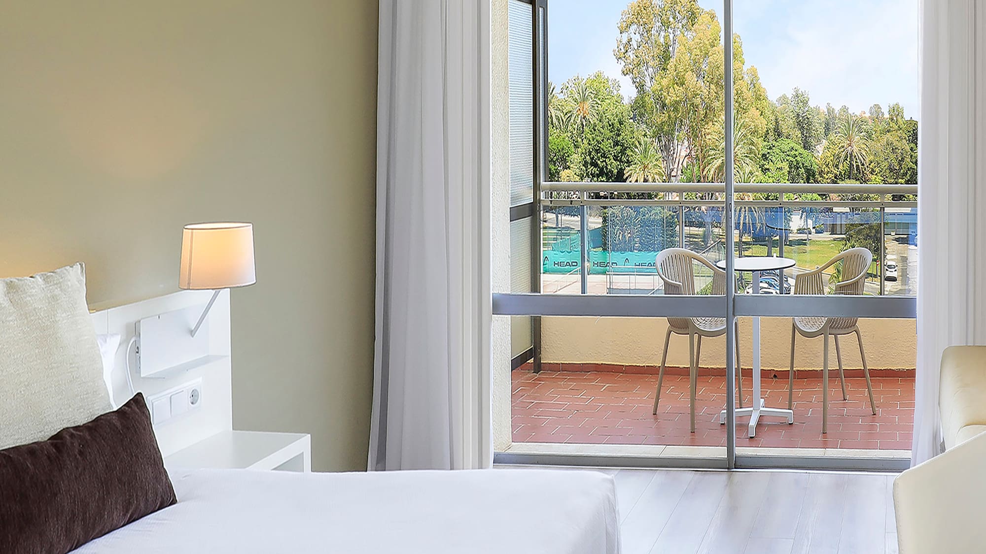 a bedroom with two beds and a glass door
