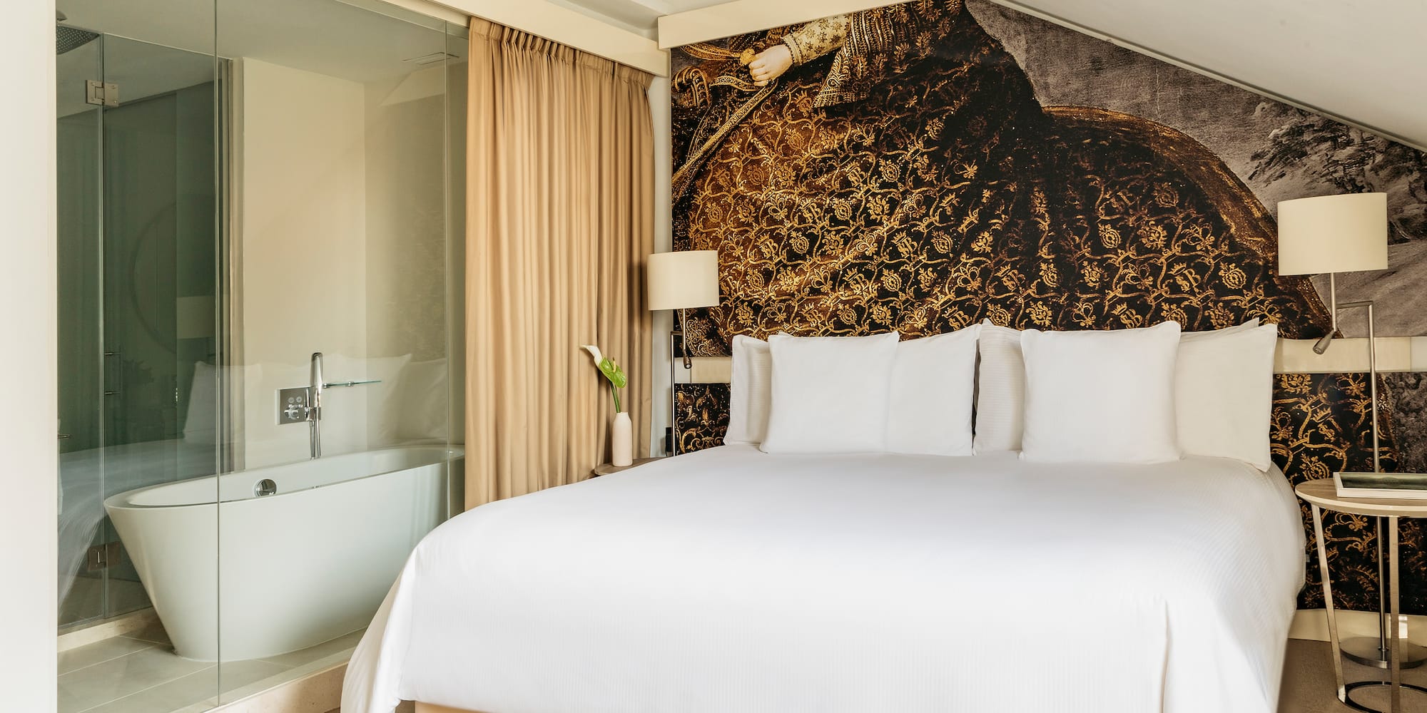 a bed with white sheets and a bathtub in a room