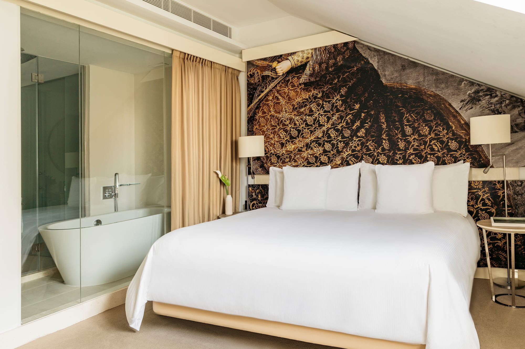 a bed with white sheets and a bathtub in a room