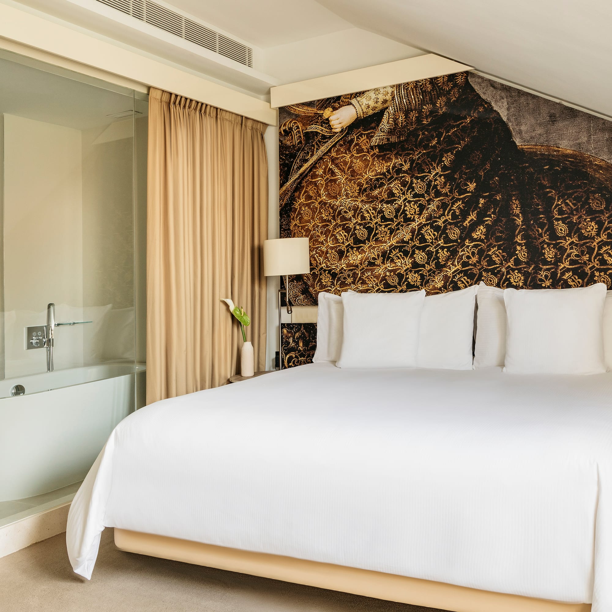 a bed with white sheets and a bathtub in a room