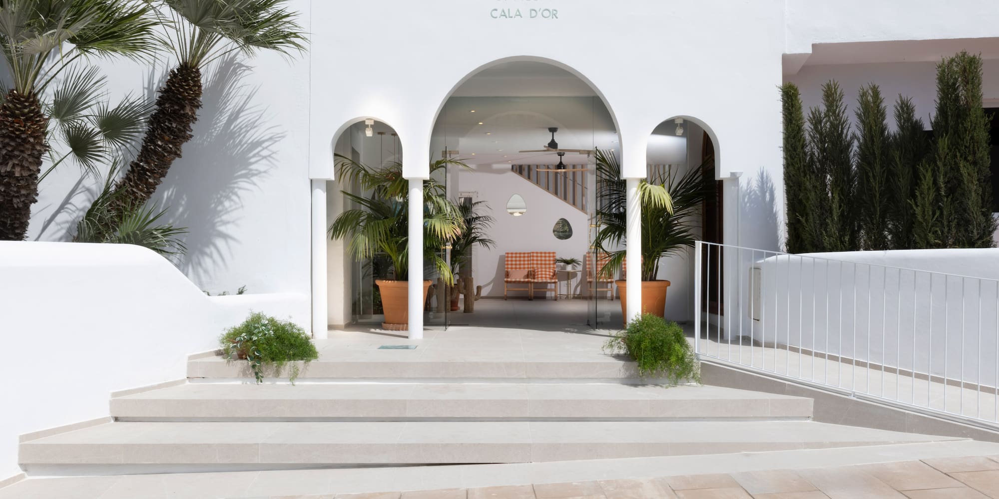 SOL by Meliá Cala d'Or hotel entrance, white arched facade, palm trees.