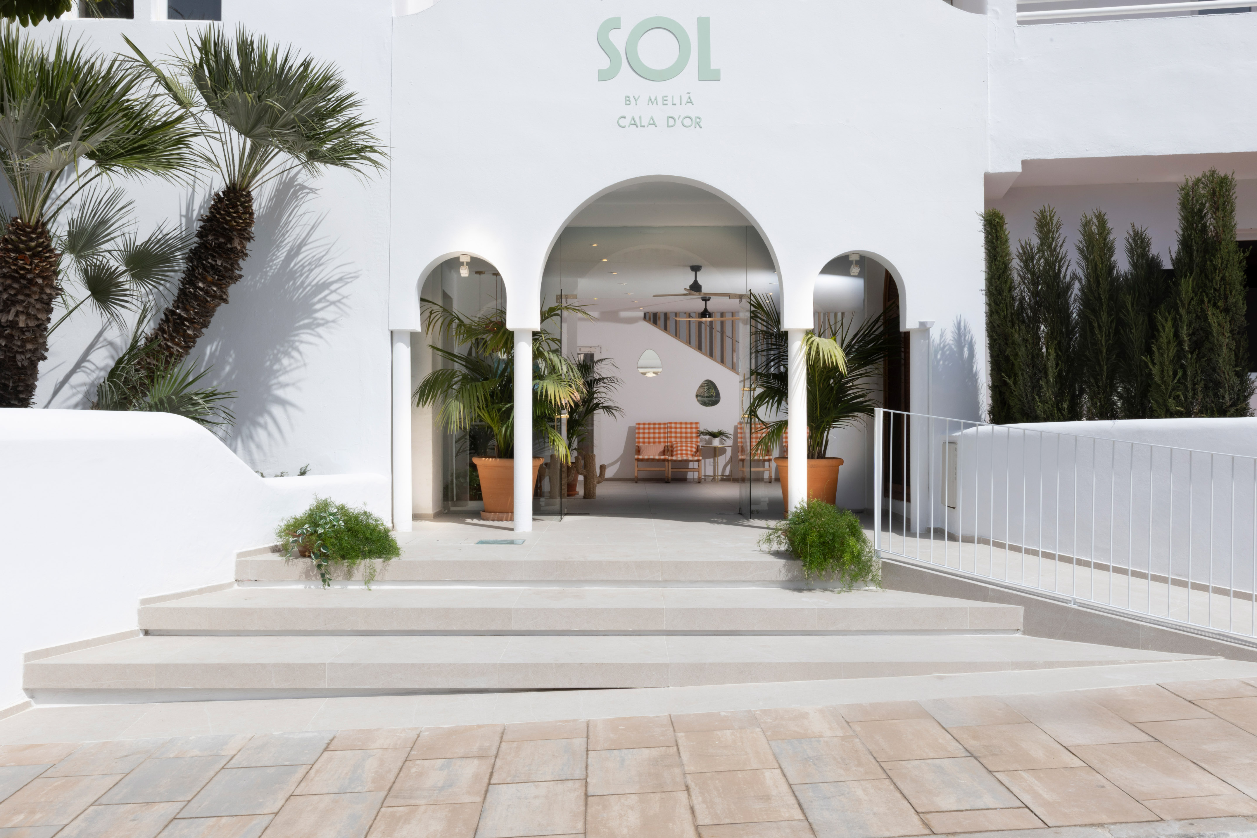 SOL by Meliá Cala d'Or hotel entrance, white arched facade, palm trees.