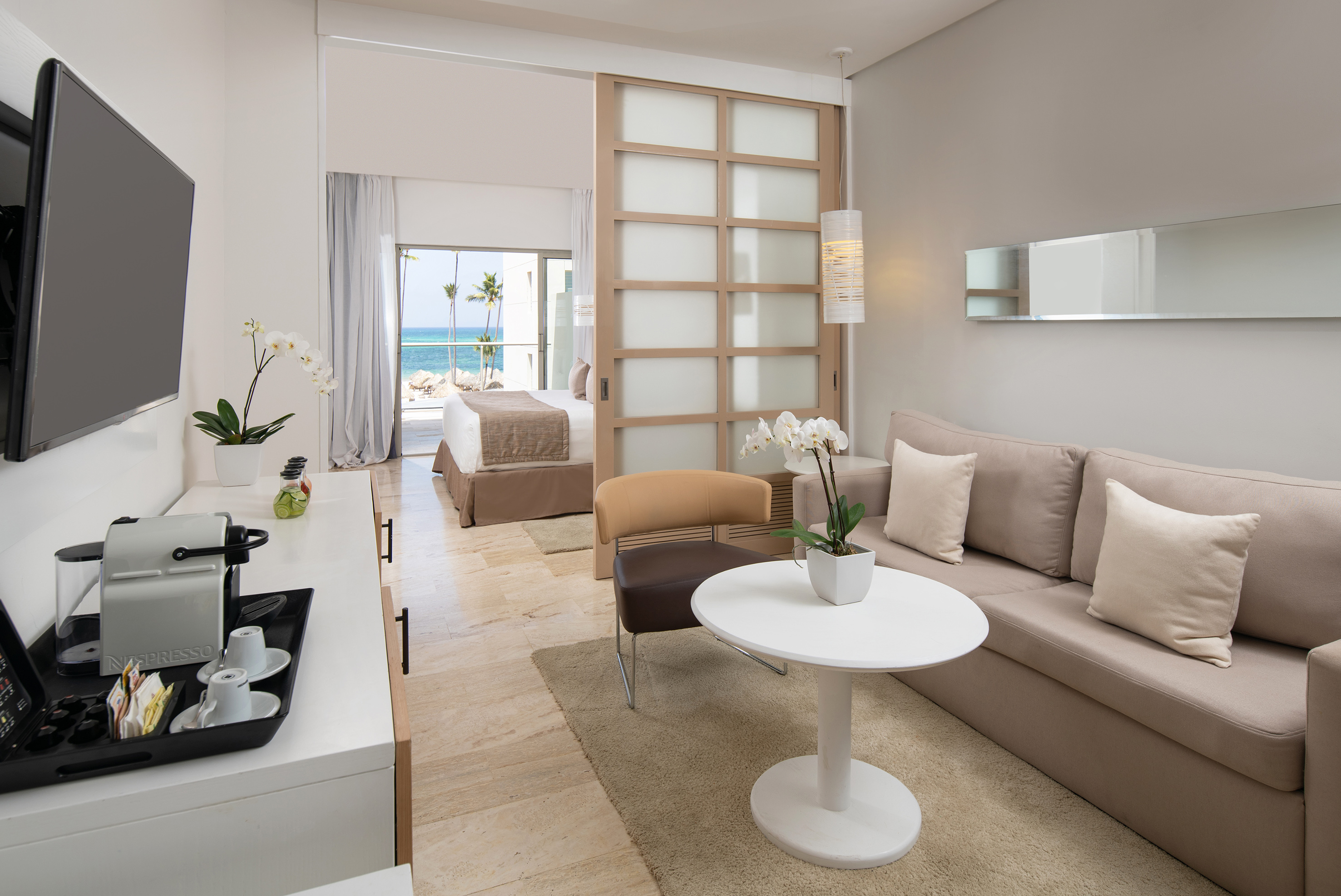 Hotel suite with ocean view, separated living area and bedroom.
