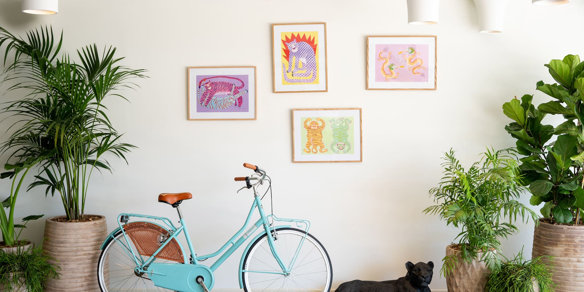 a blue bicycle next to a black panther lying on a wood floor
