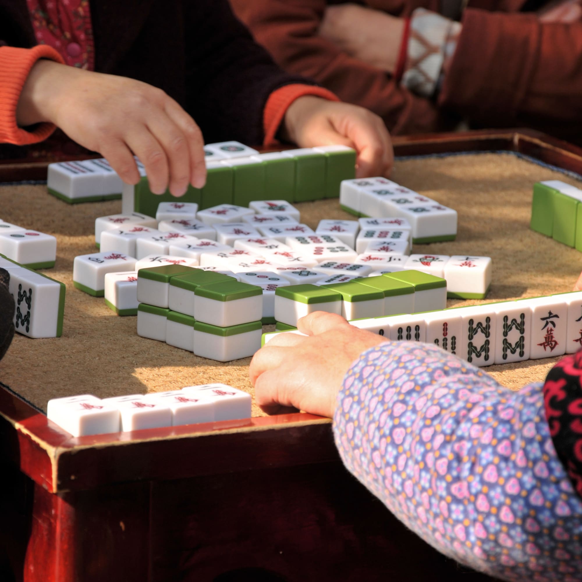 a group of people playing mahjong