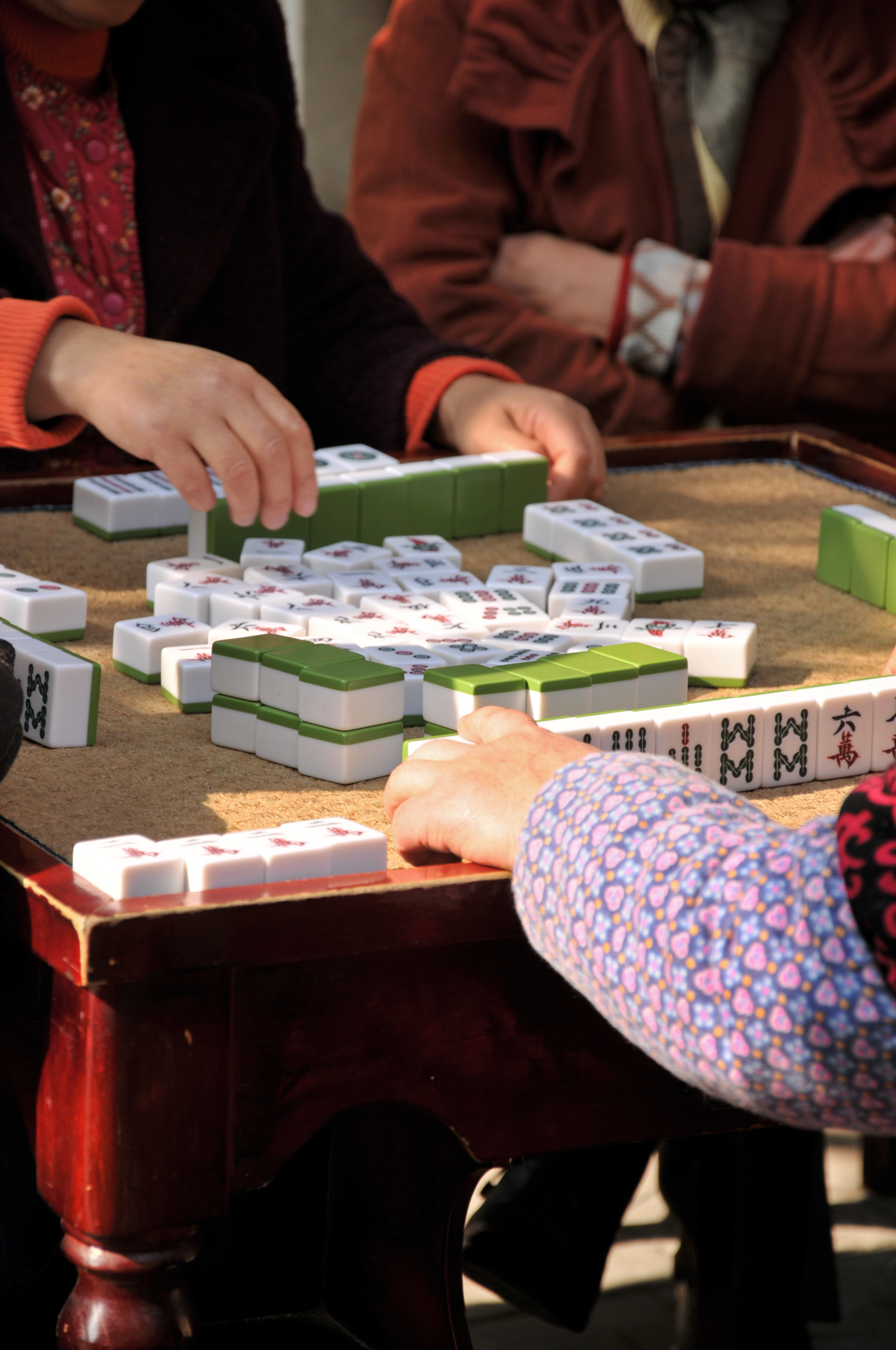 a group of people playing mahjong