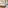 Hotel bedroom with large bed, wood headboard, tiled floor, and patio door.