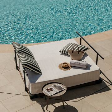 a bed with a basket and a table next to a pool