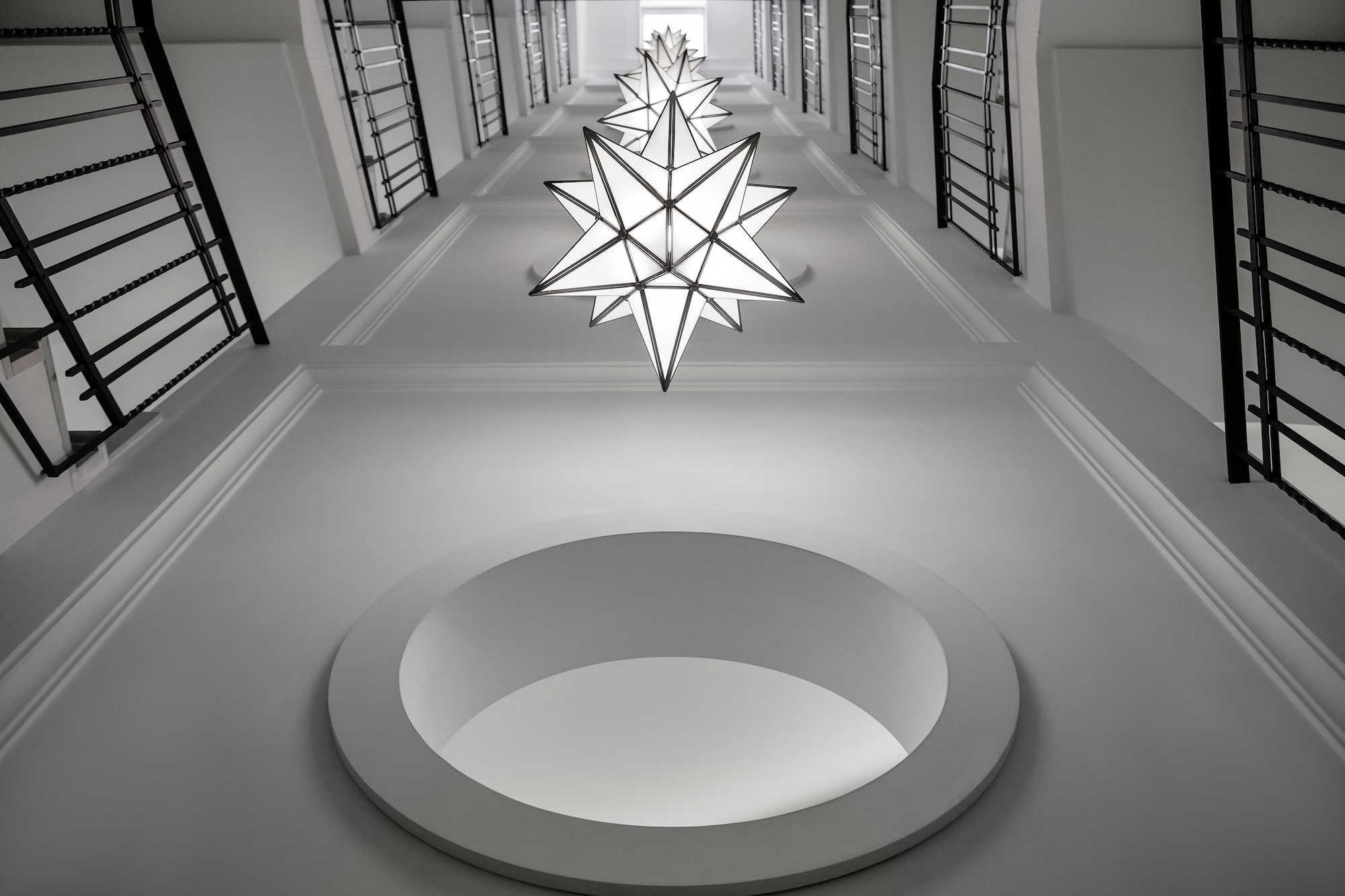 Modern white stairwell, star-shaped lights, black railings, circular ceiling. - Villa Agrippina Gran Meliá, Roma