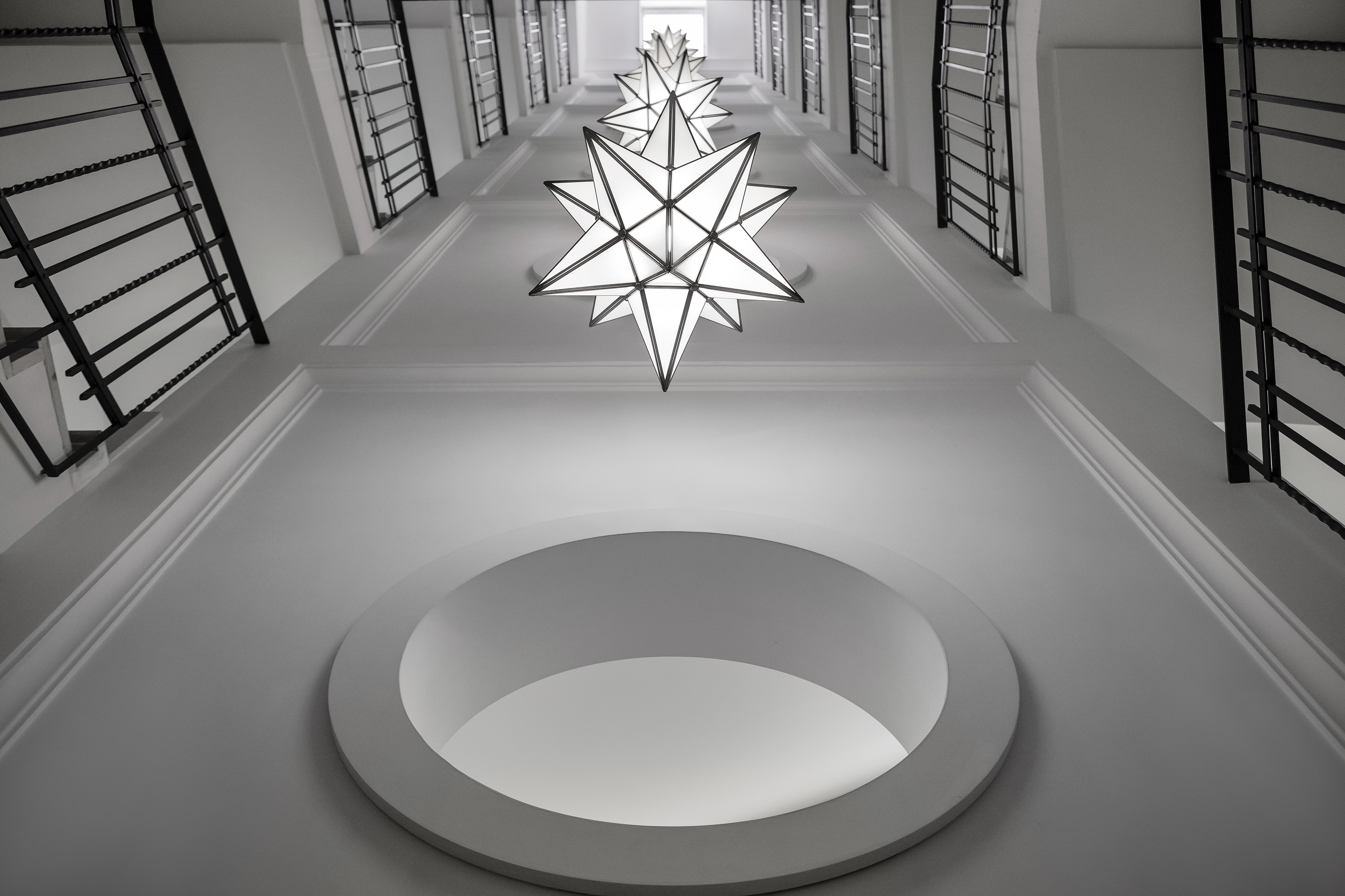 Modern white stairwell, star-shaped lights, black railings, circular ceiling. - Villa Agrippina Gran Meliá, Roma