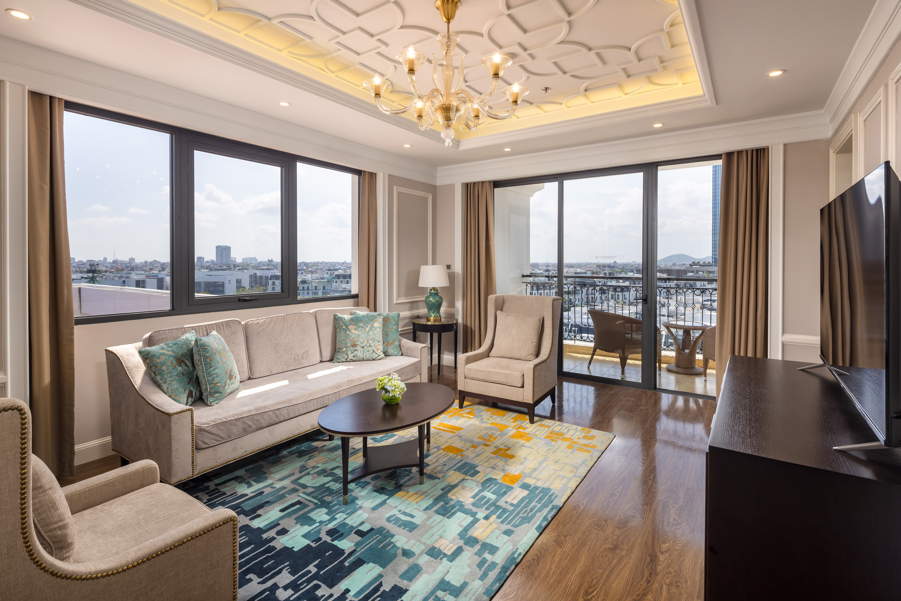 Luxury hotel living room with city view, modern sofa, and elegant decor.