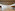 Empty modern event space with marble floor, wood beams, and projector.