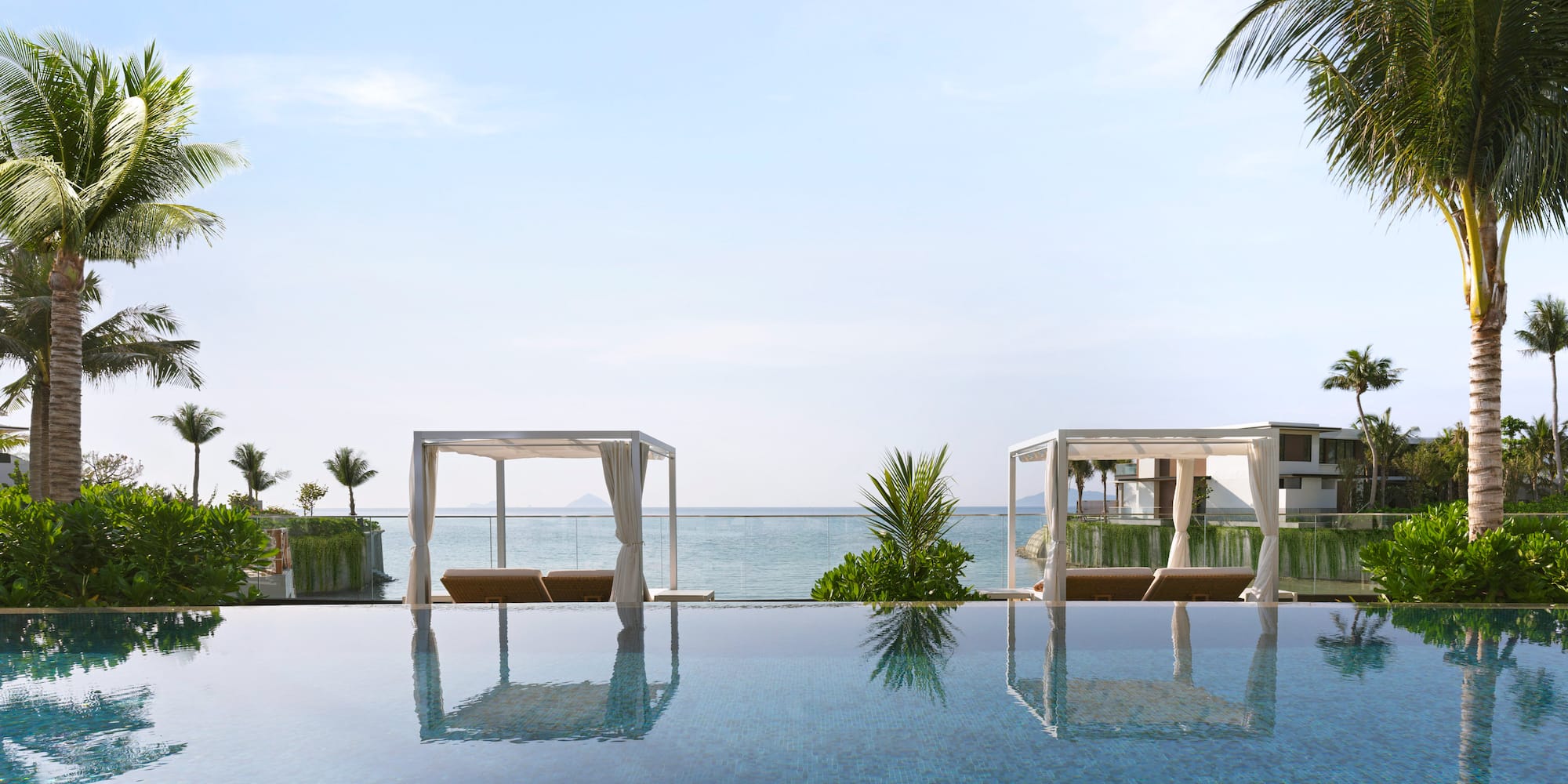 a pool with a view of the ocean and a beach