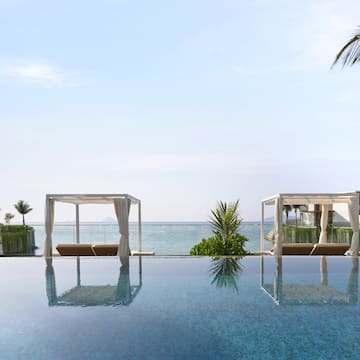 a pool with a view of the ocean and a beach