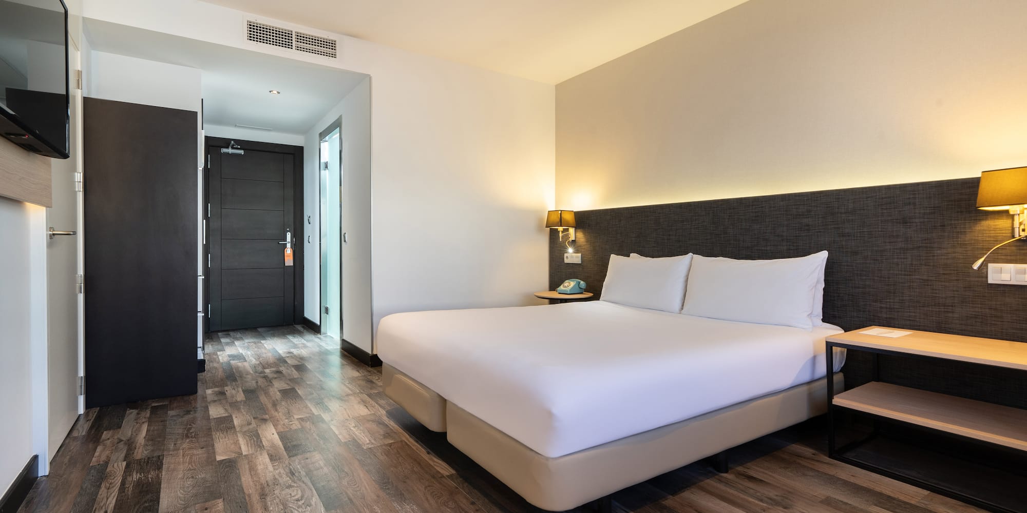 a room with a bed and a wood floor