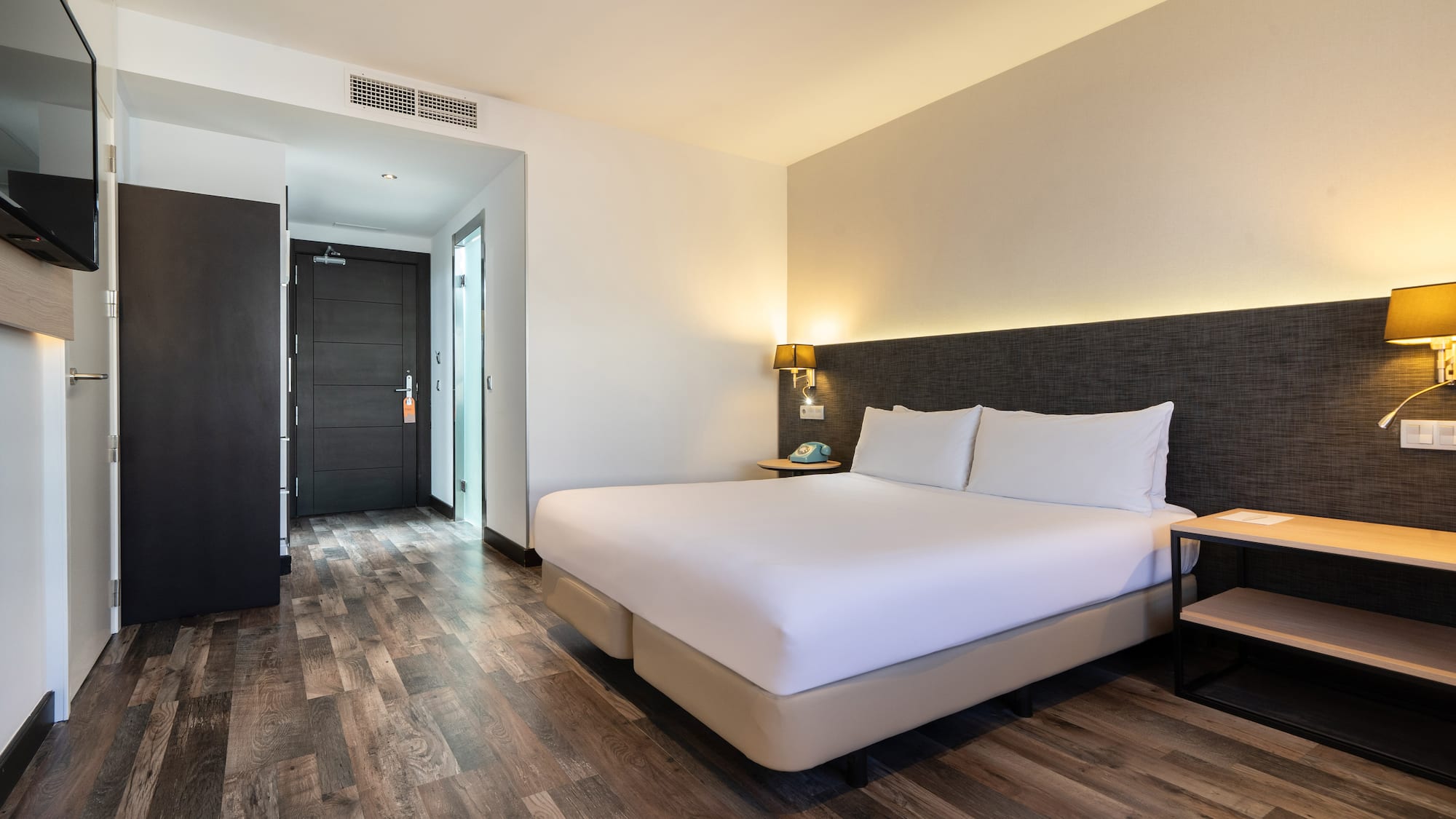 a room with a bed and a wood floor