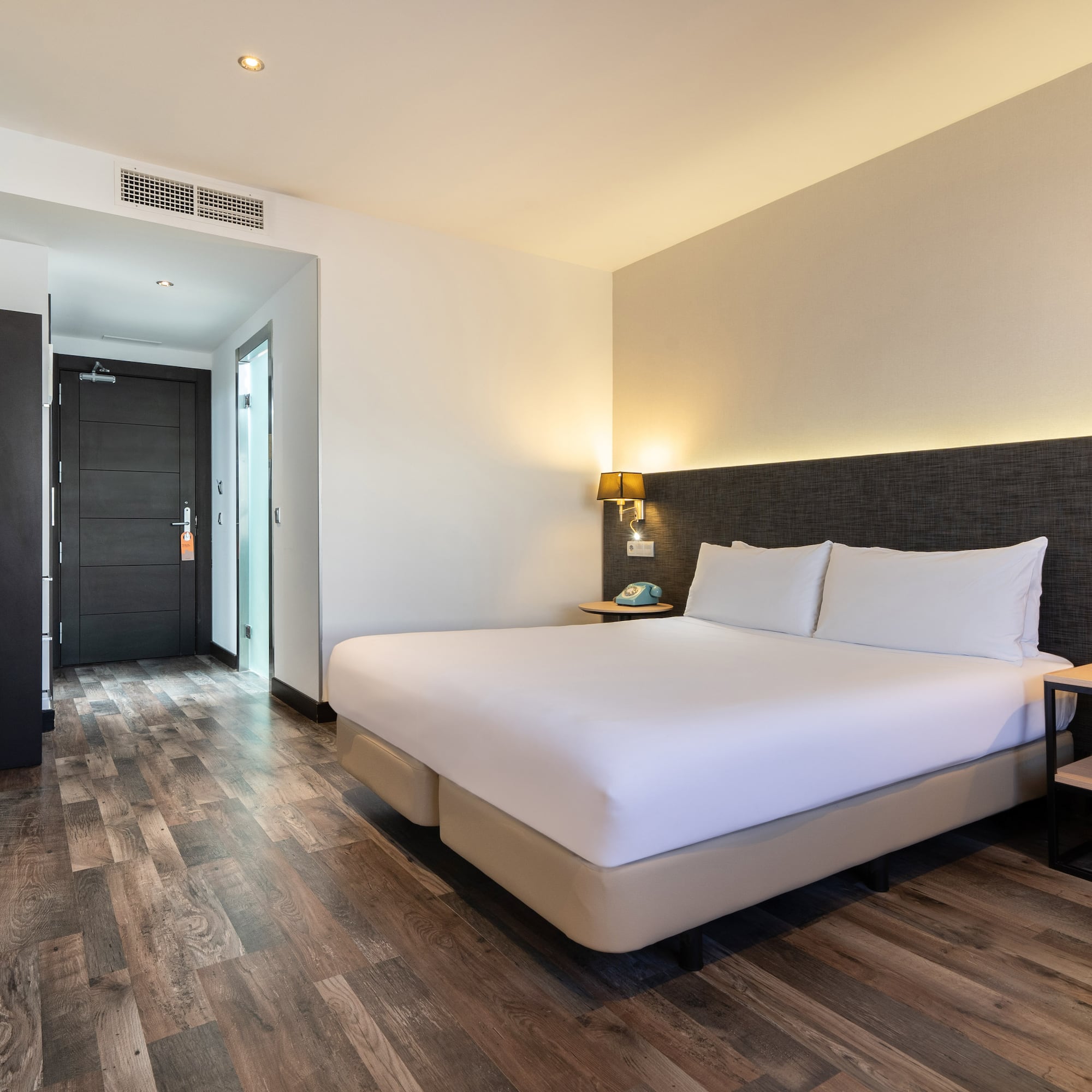 a room with a bed and a wood floor