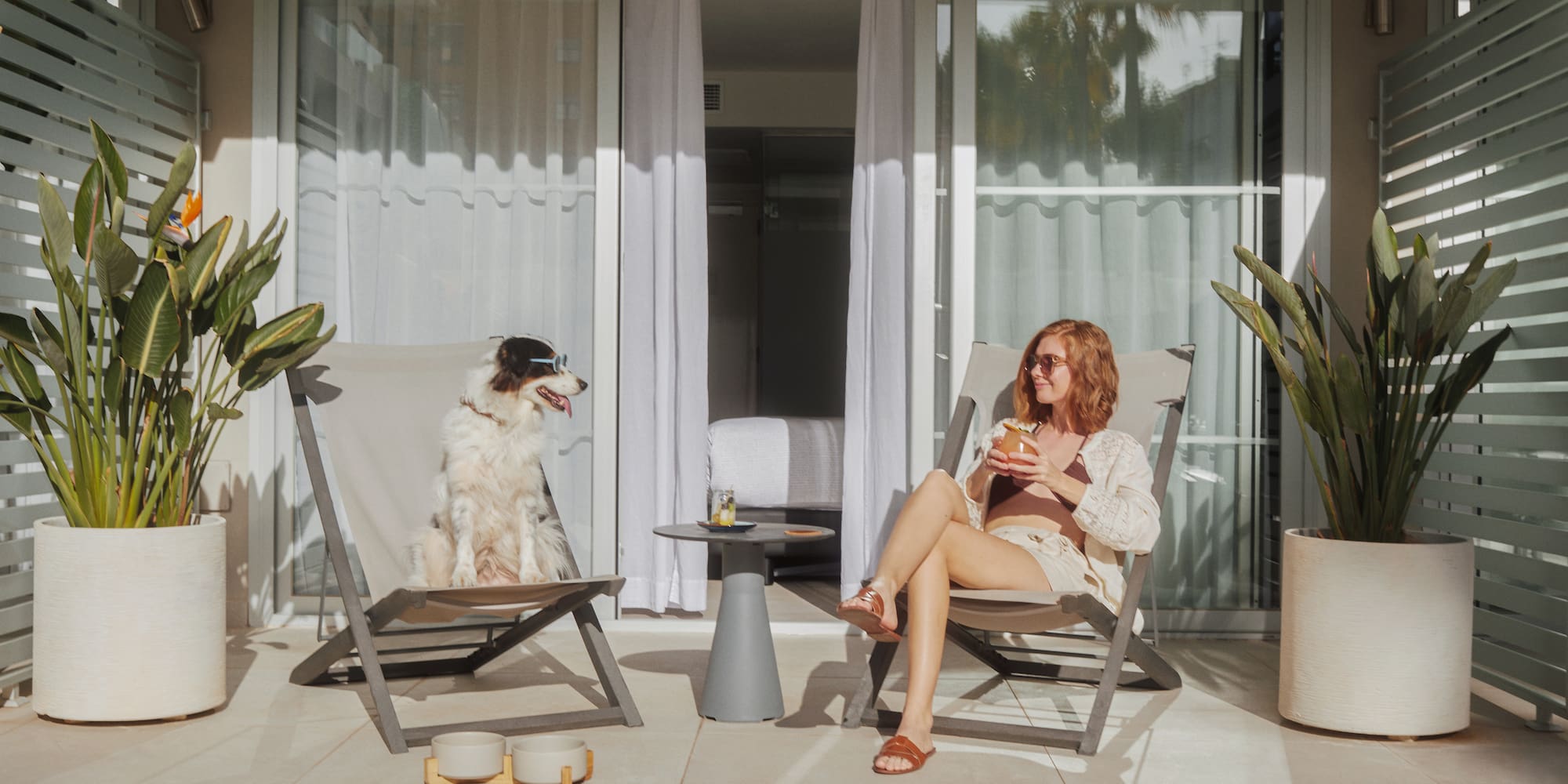a woman and dog sitting in chairs on a patio