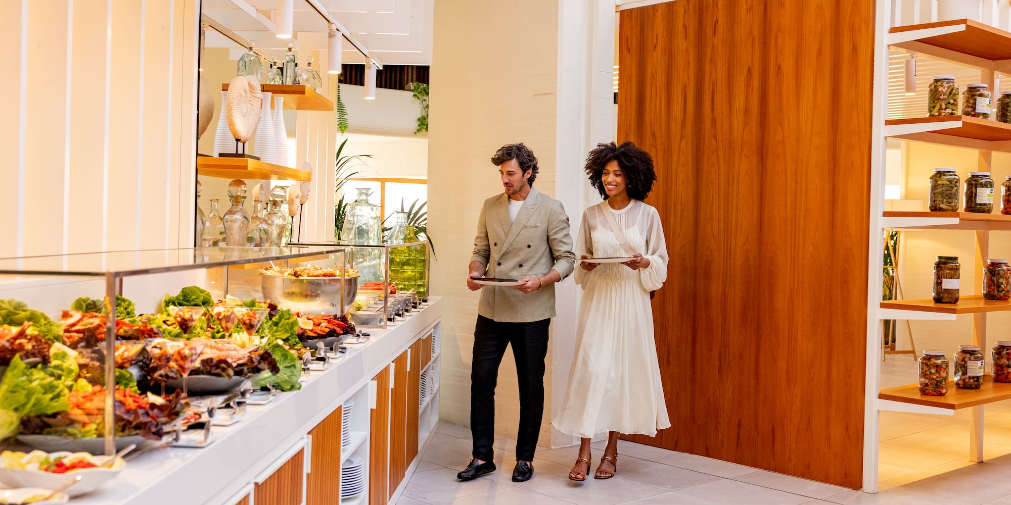 a man and woman standing in front of a buffet