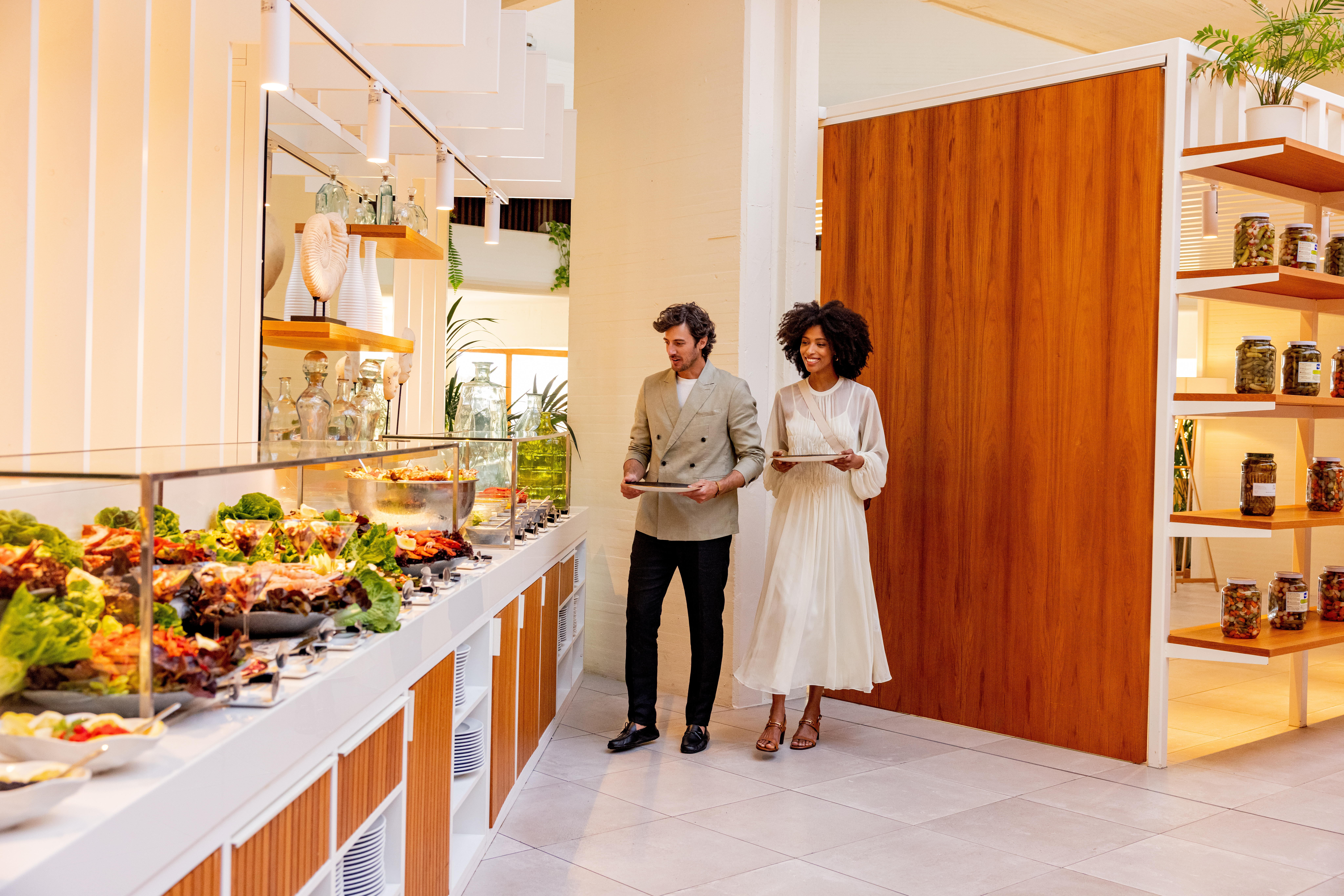 Guests choosing fresh food from a modern hotel buffet.