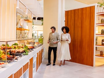 a man and woman standing in front of a buffet