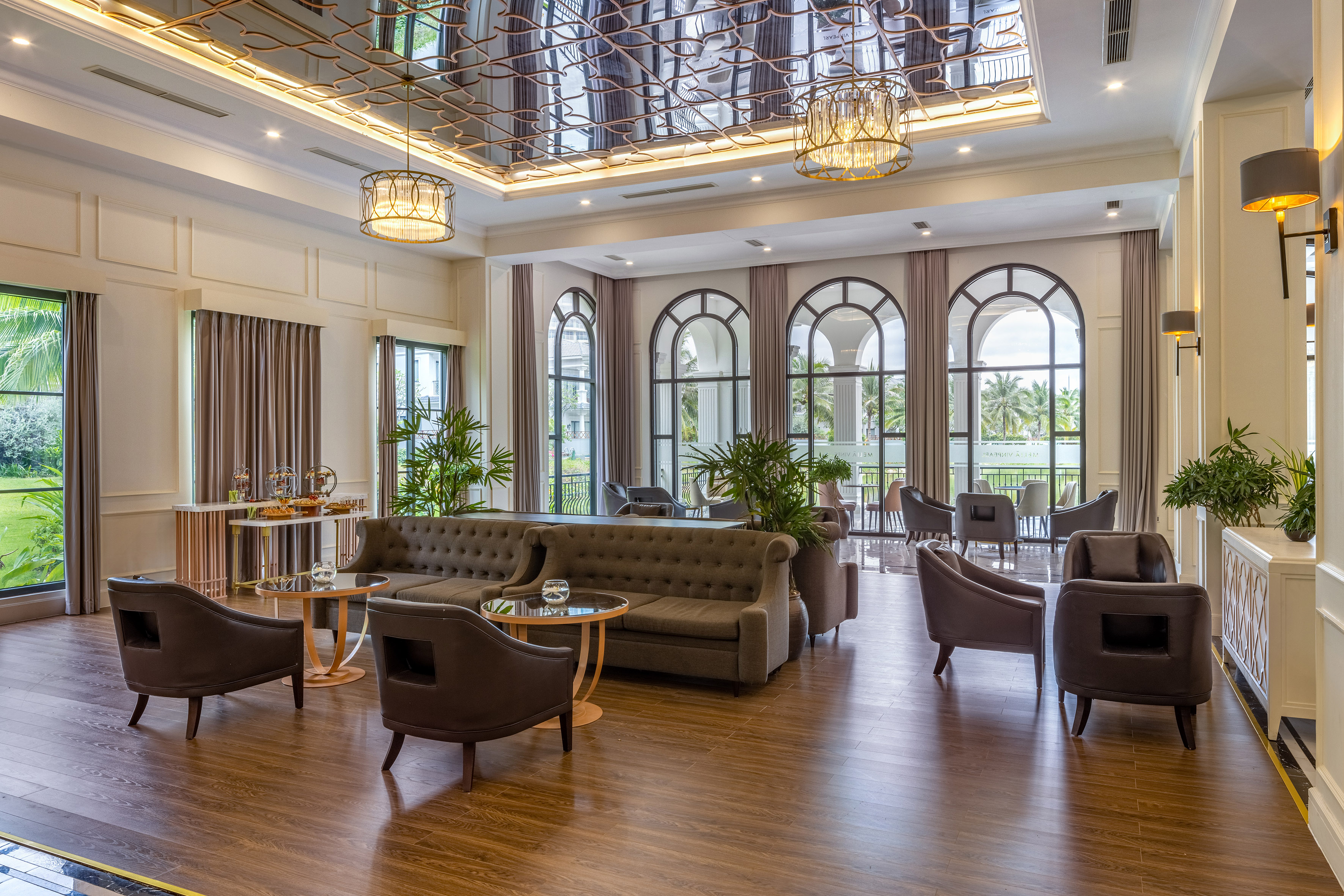Elegant hotel lobby with luxurious seating, arched windows, and ornate ceiling.
