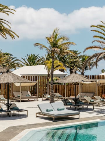 a pool with lounge chairs and umbrellas