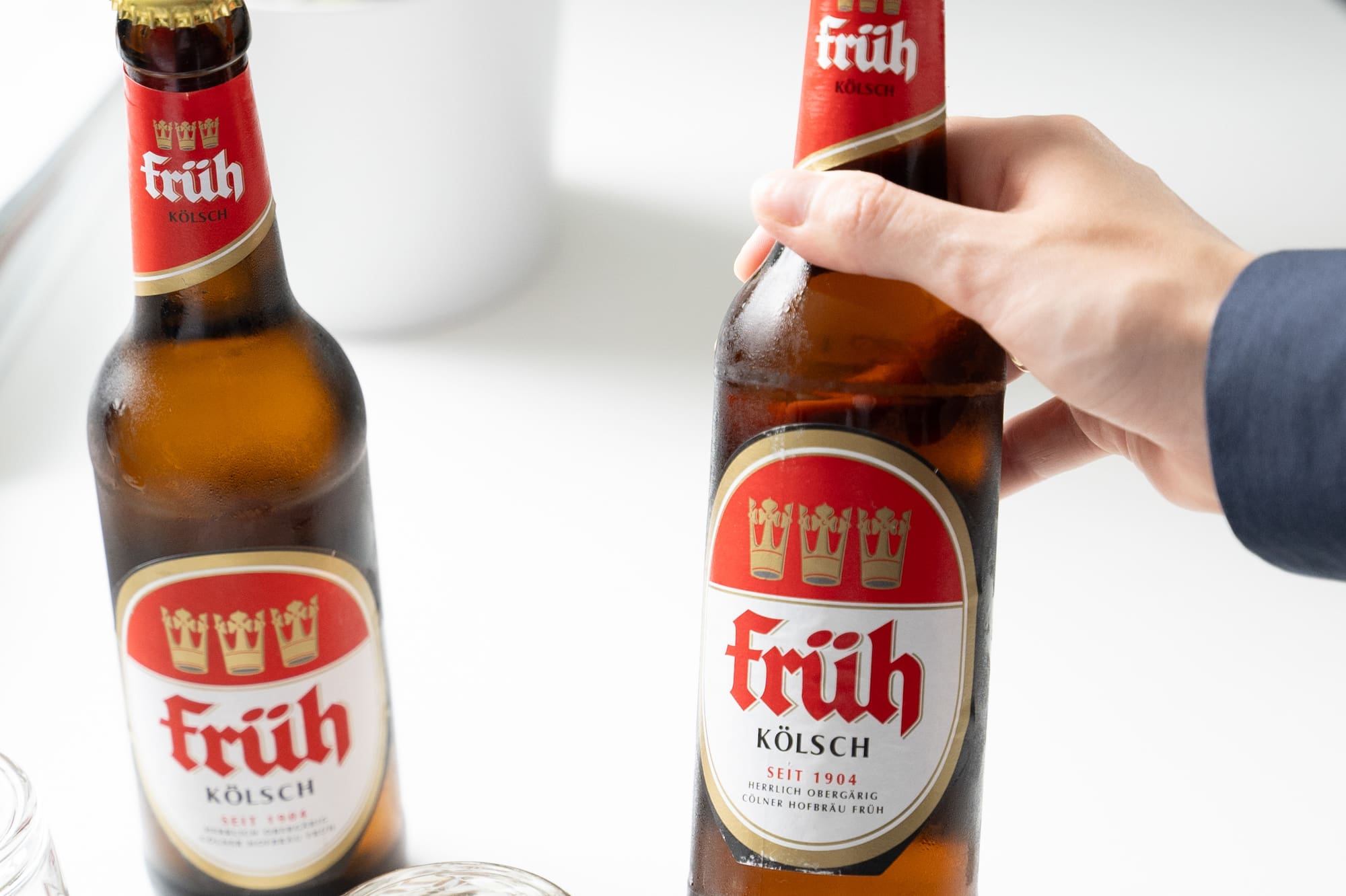 a hand holding a bottle of beer