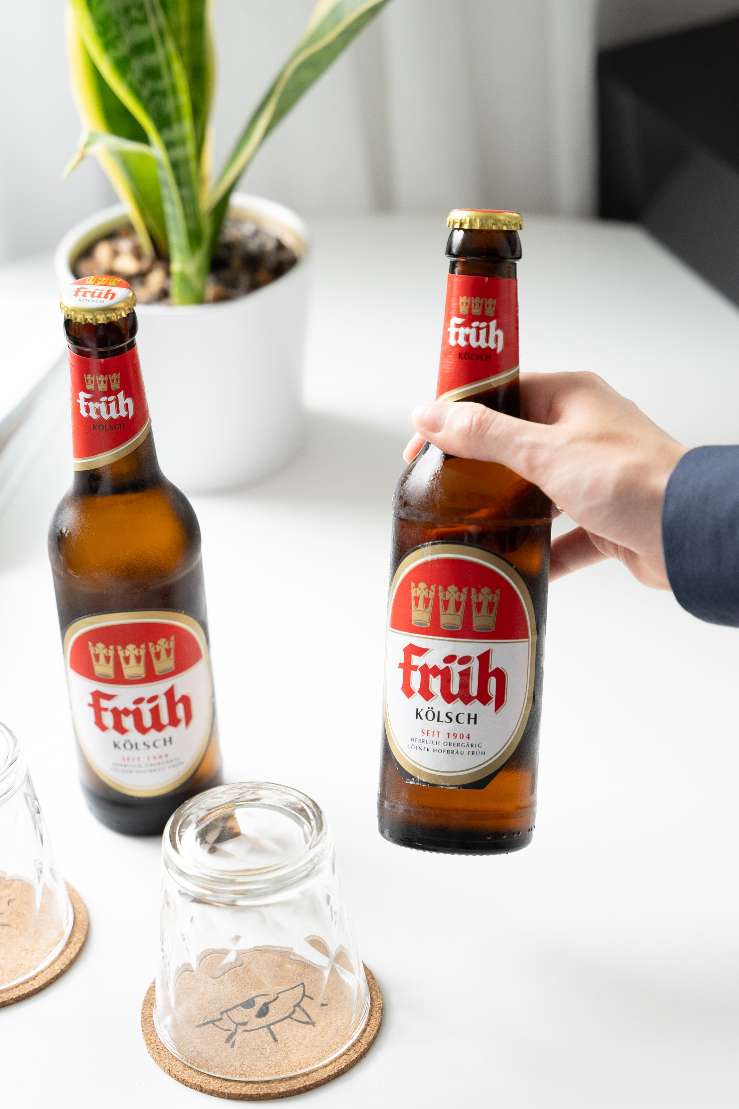 a hand holding a bottle of beer