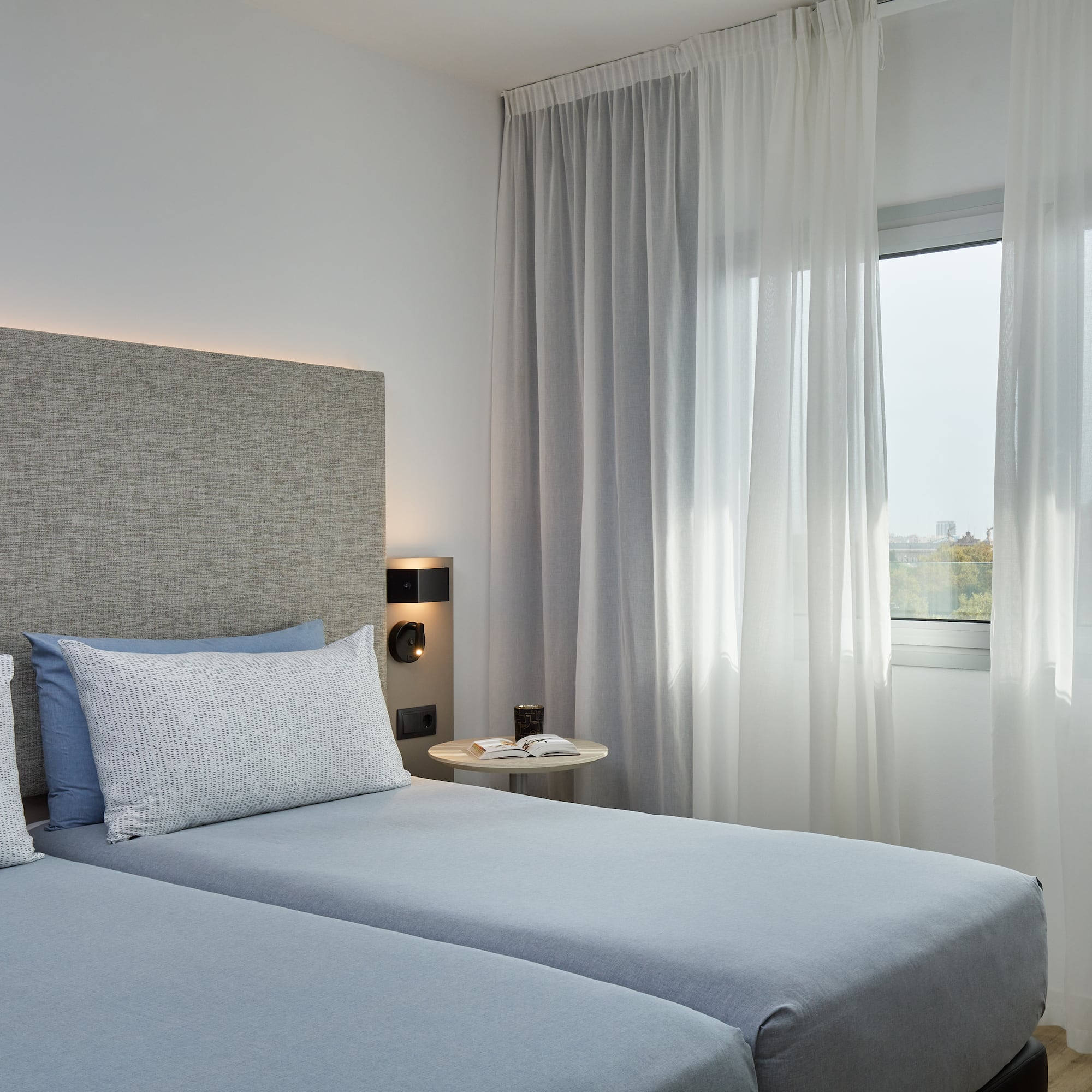 a bedroom with two beds and a window