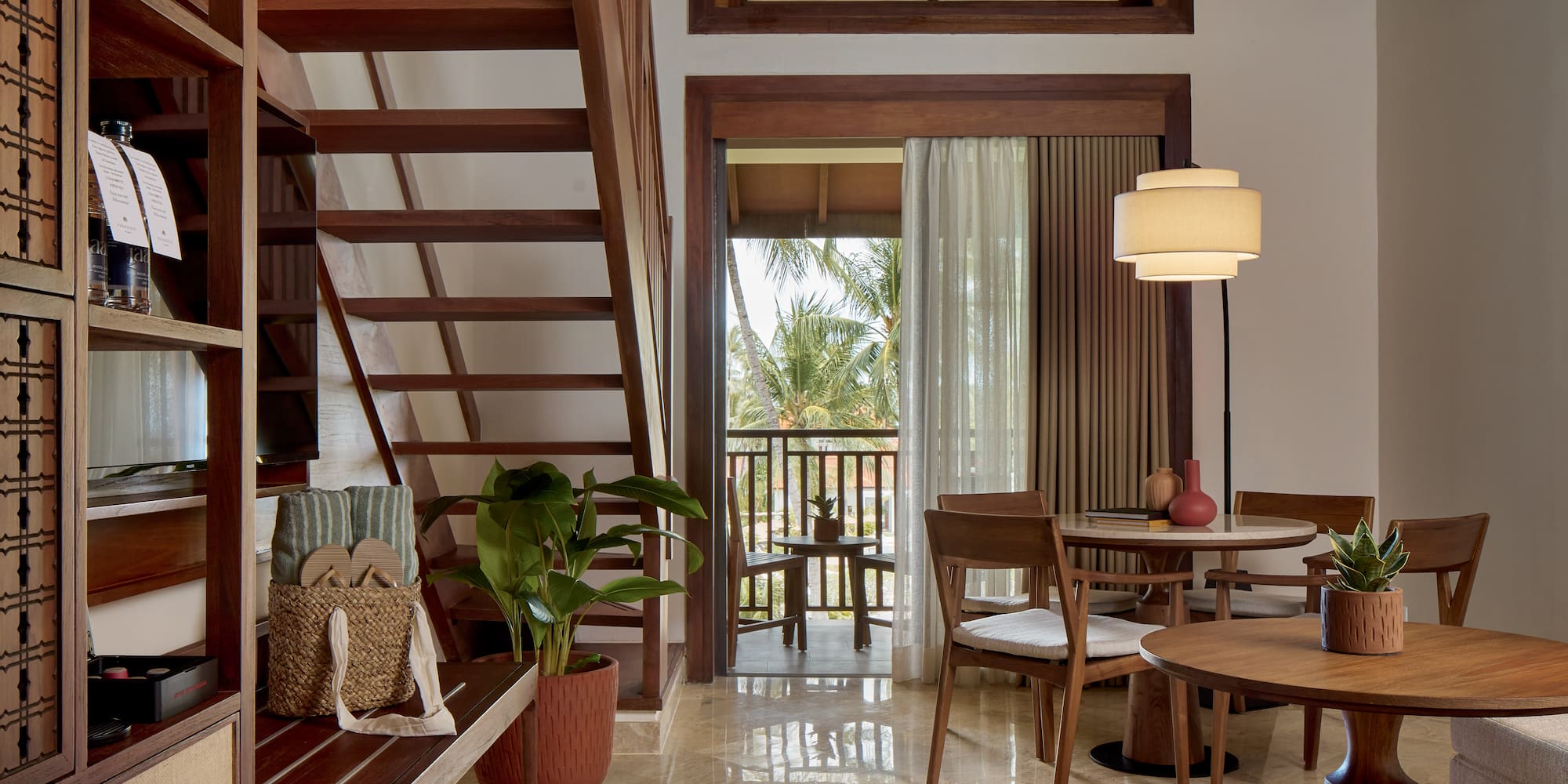 a room with a staircase and a table and chairs