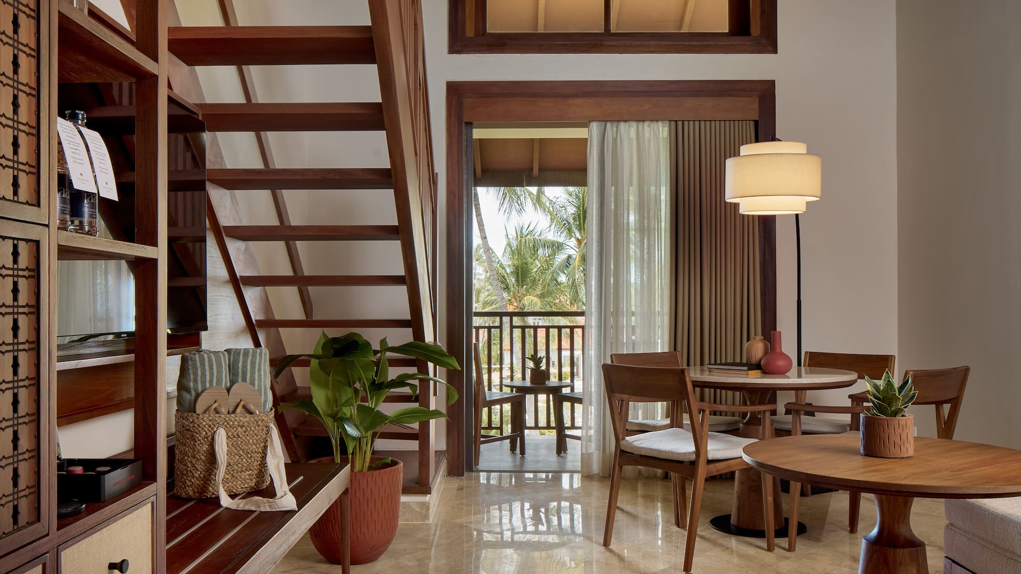 a room with a staircase and a table and chairs