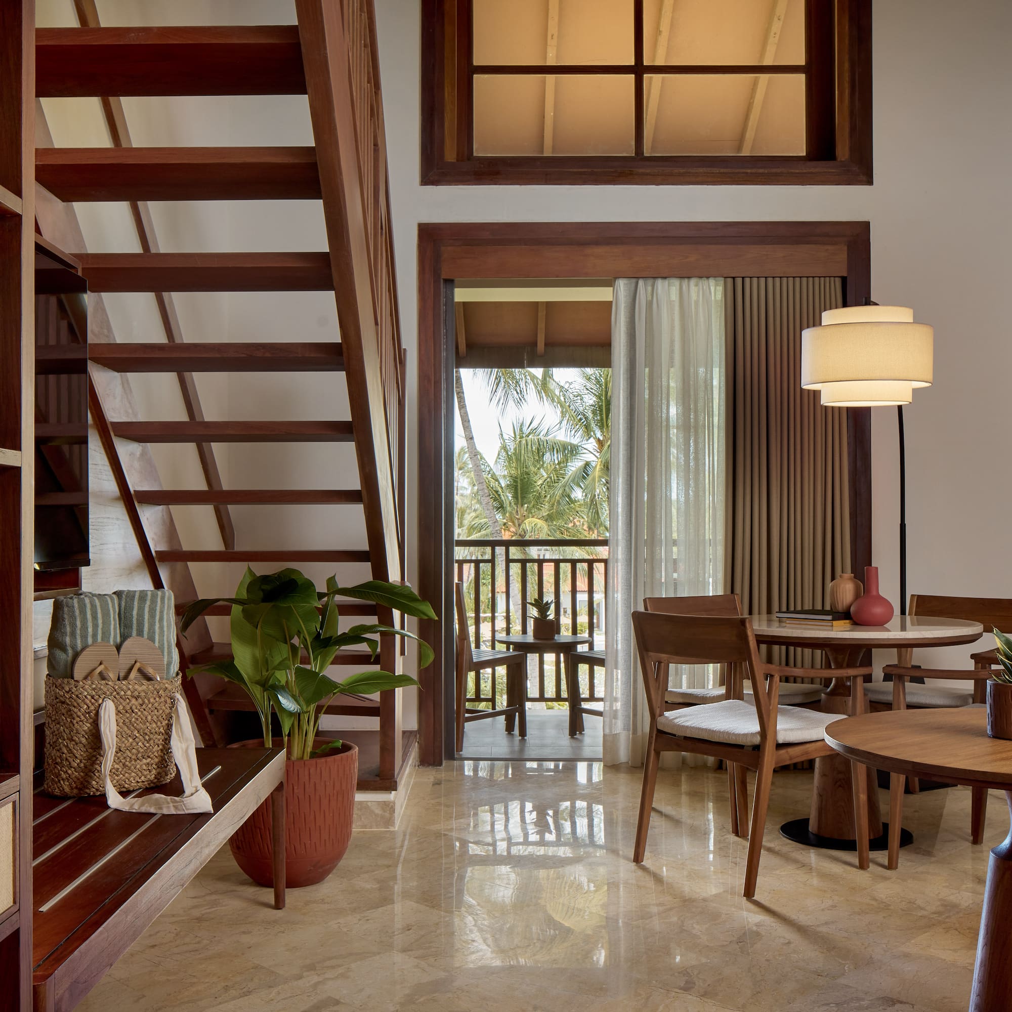 a room with a staircase and a table and chairs